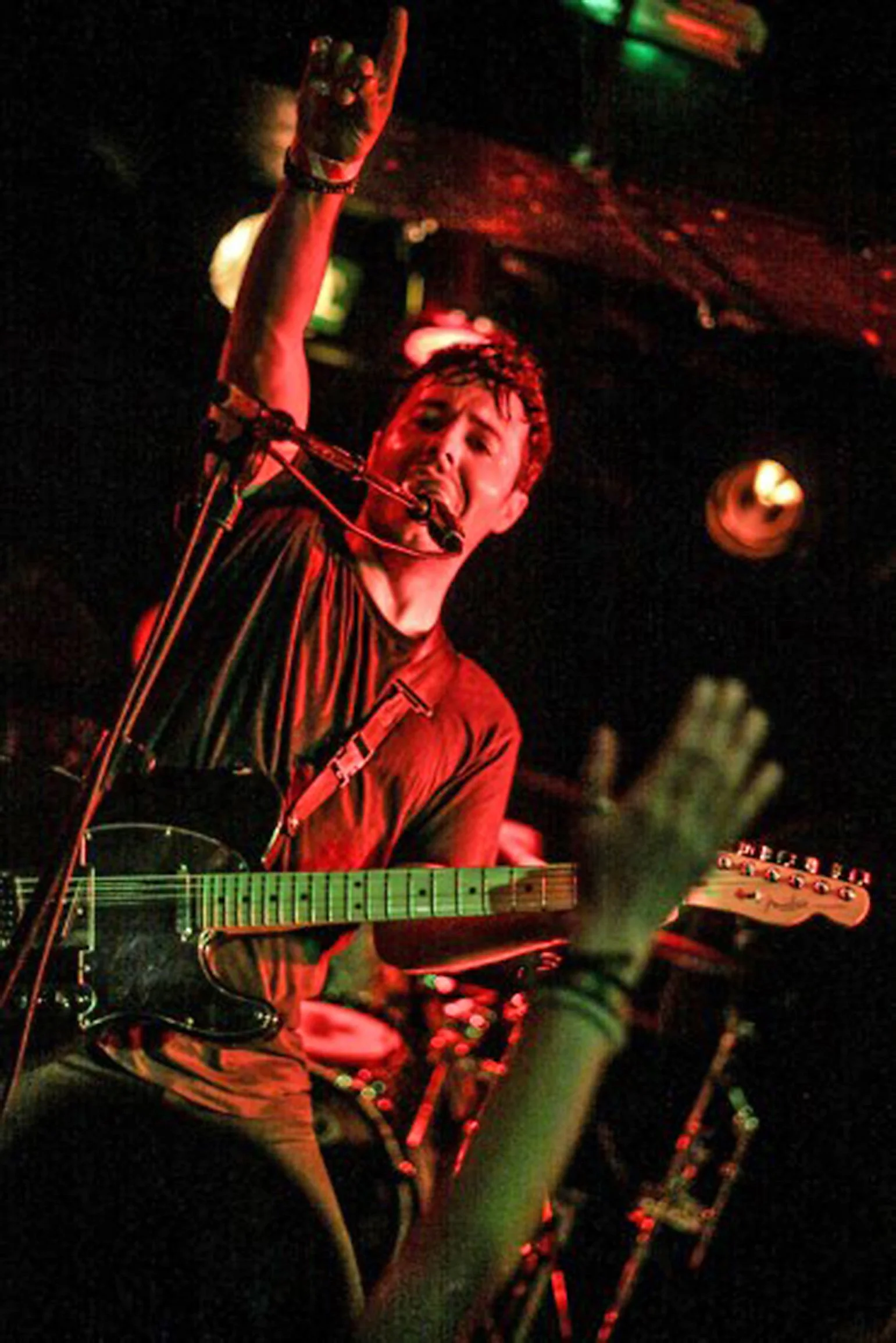Kyshera band singer, James Kennedy playing a live concert with the rock band Kyshera in London with his hand in the air