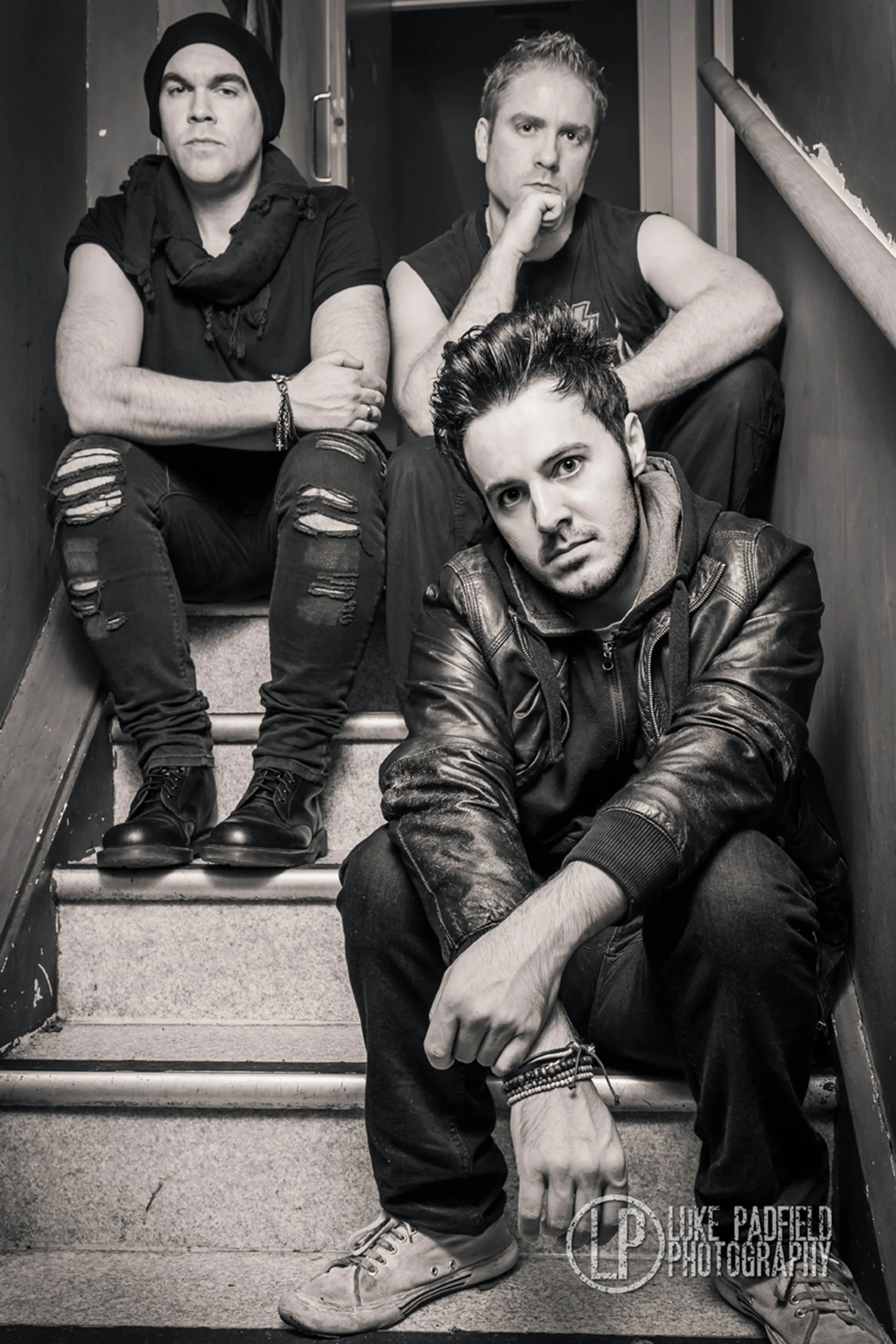 Kyshera, the alternative rock band from Cardiff Wales, sitting in a stairwell posing for a band photoshoot
