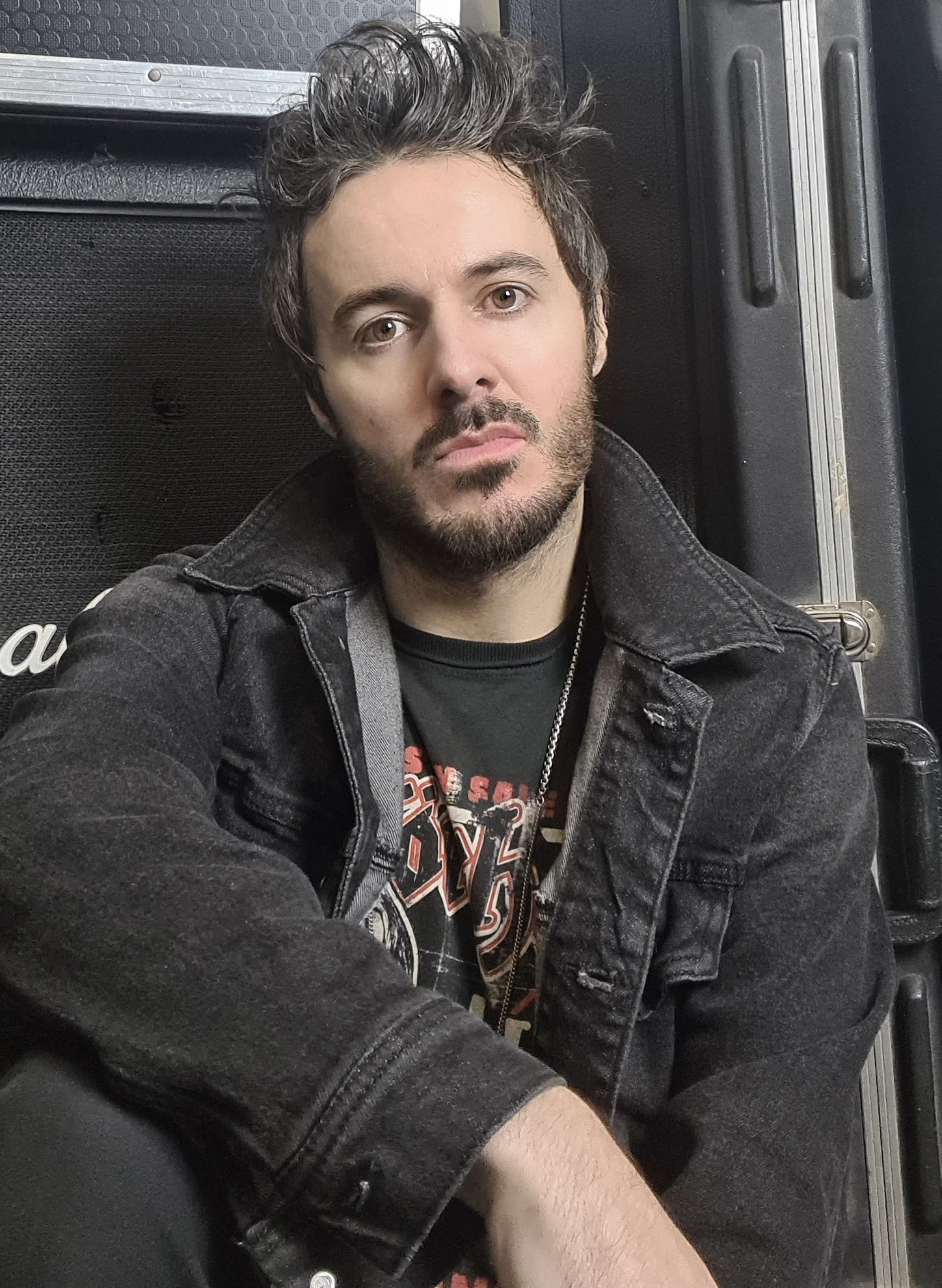 James Kennedy, the singer, musician, author and guitarist in the band 'James Kennedy and The Underdogs' posing in front of a Marshall amplifier wearing a denim jacket