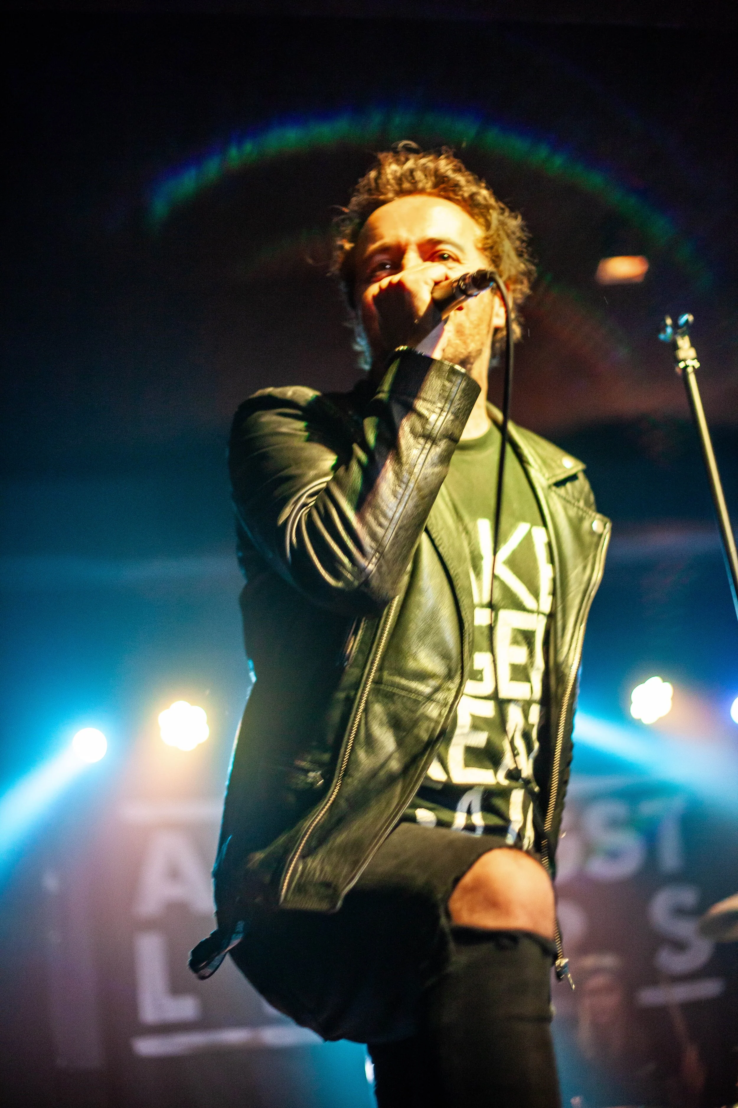 James Kennedy, the singer, author and podcaster from Wales singing live on stage with his band 'James Kennedy and The Underdogs' and wearing a leather jacket 