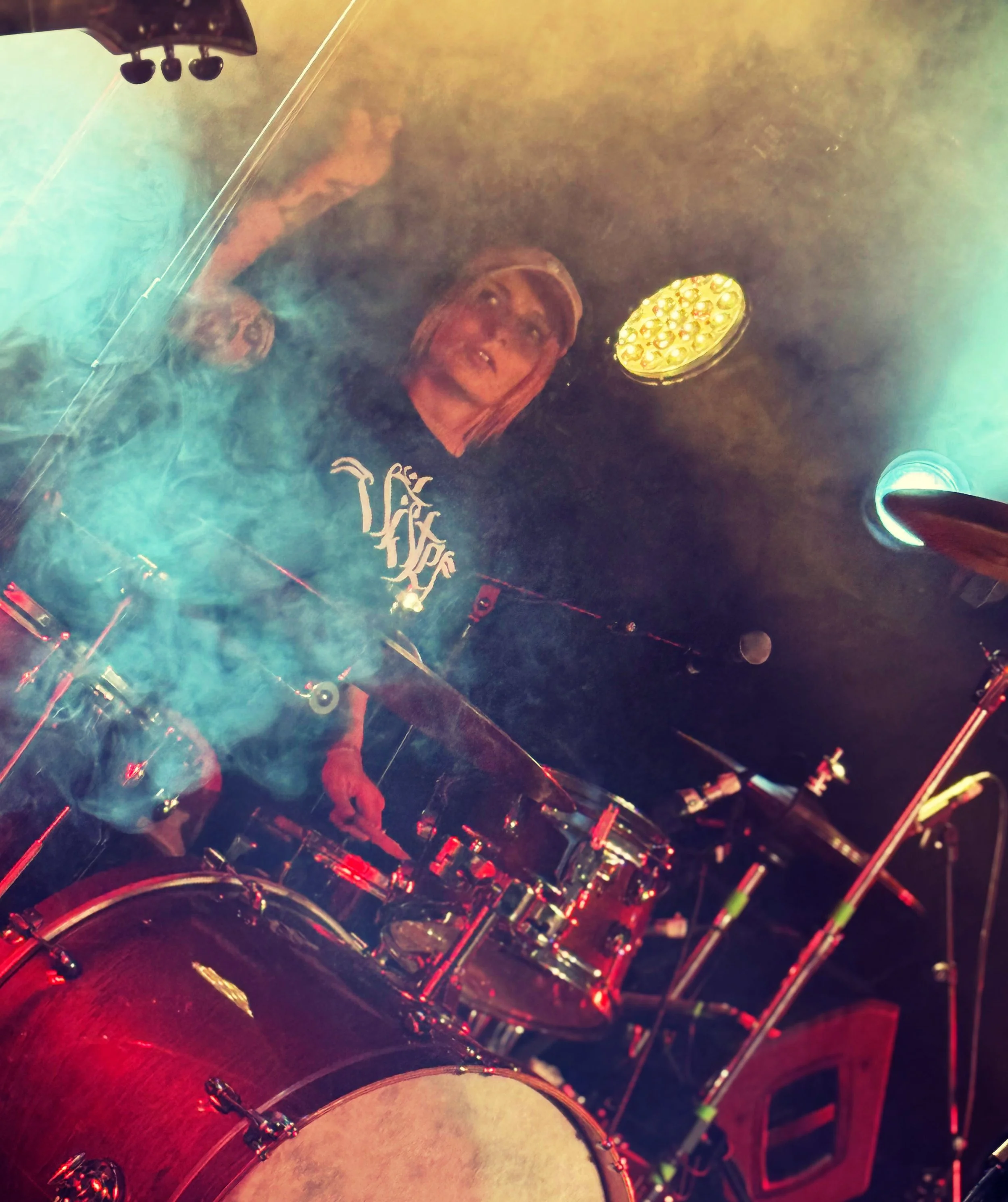 Aggy Nowicka, drummer in the Welsh hard rock band 'James Kennedy and The Underdogs' playing drums on stage covered in stage smoke