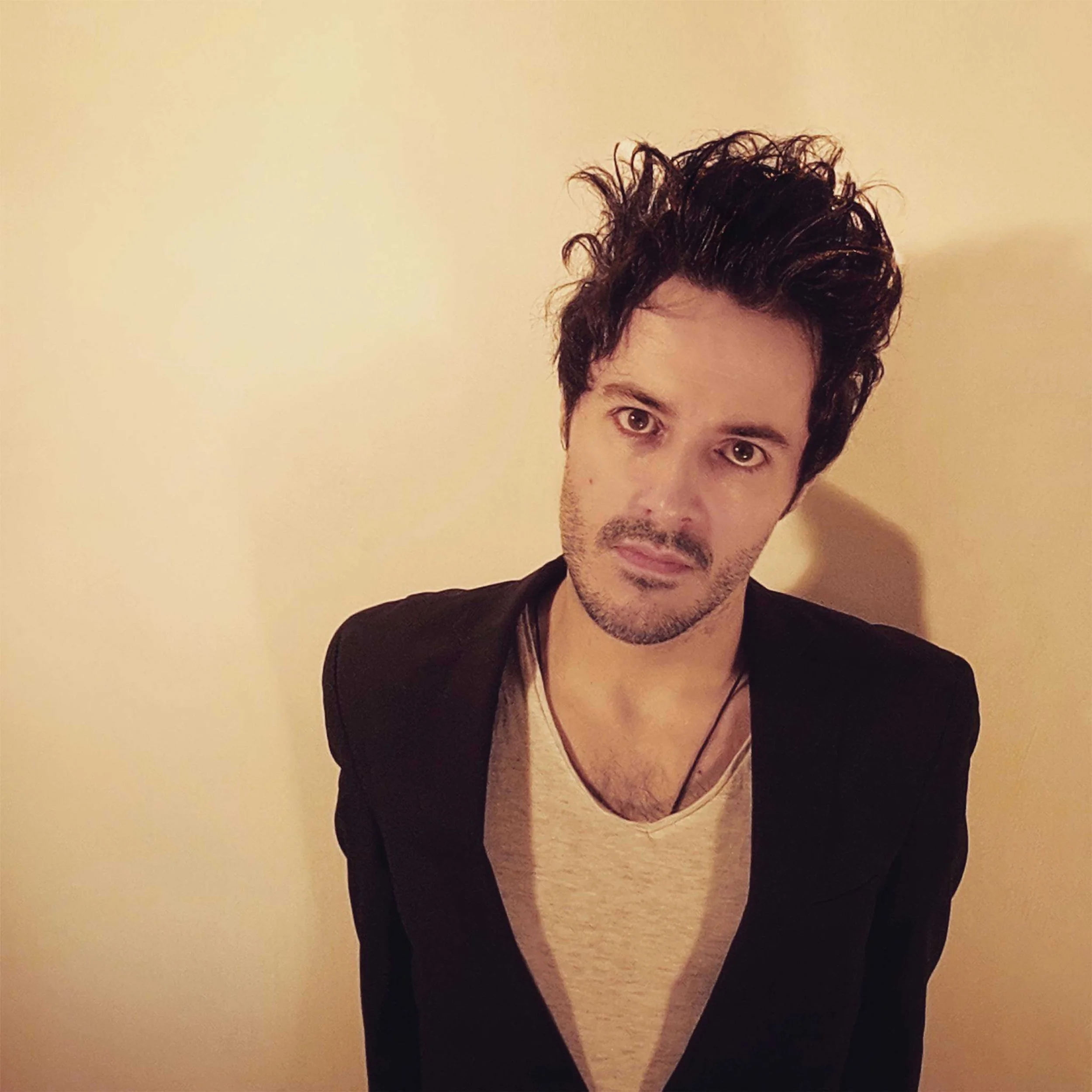 James Kennedy, the singer and author from Wales, posing in a suit jacket with spikey hair