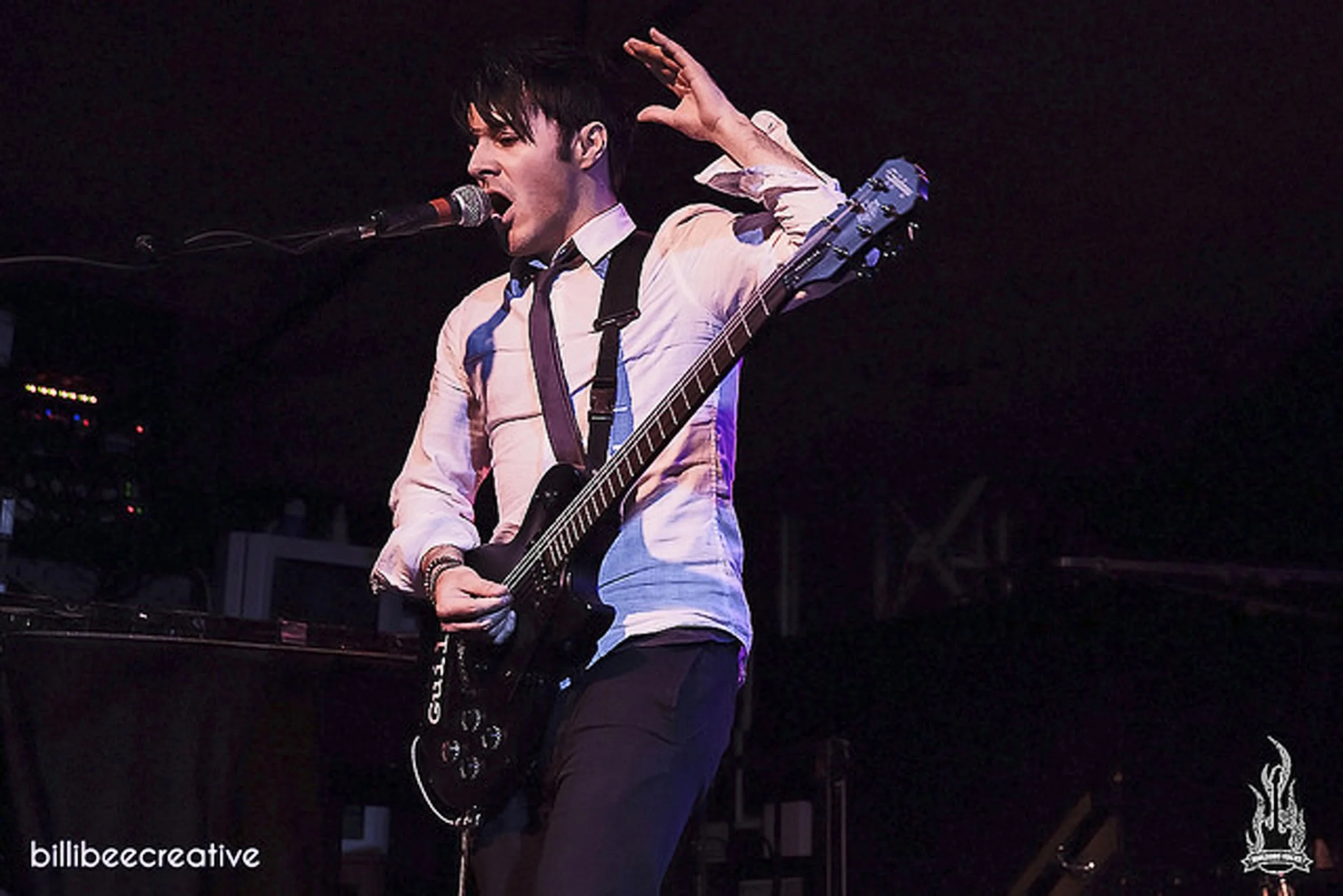 Kyshera frontman, James Kennedy playing guitar and singing at a Kyshera concert in Wolverhampton wearing a shirt and tie