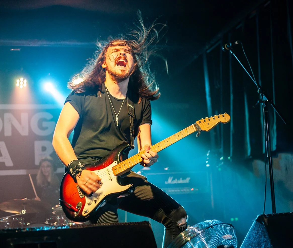 Jack Davies, the guitarist with the rock band 'James Kennedy and The Underdogs' playing a Fender Stratocaster and screaming on stage