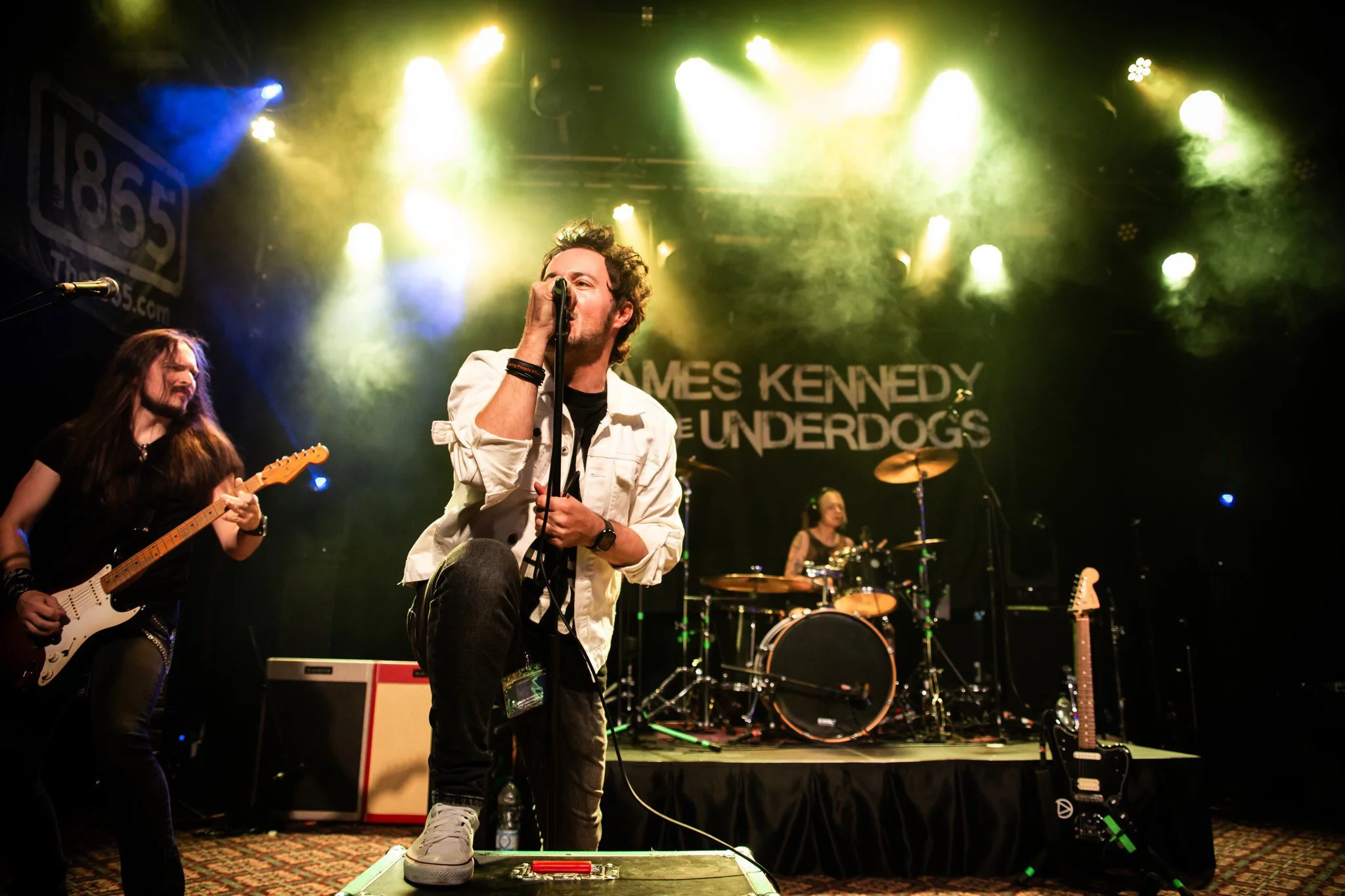 The hard rock band from Wales, 'James Kennedy and The Underdogs', live on stage under yellow stage lights during a UK tour