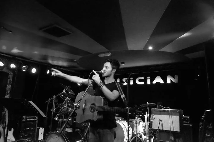 James Kennedy, the singer and musician playing an acoustic guitar at a solo concert in Leicester UK