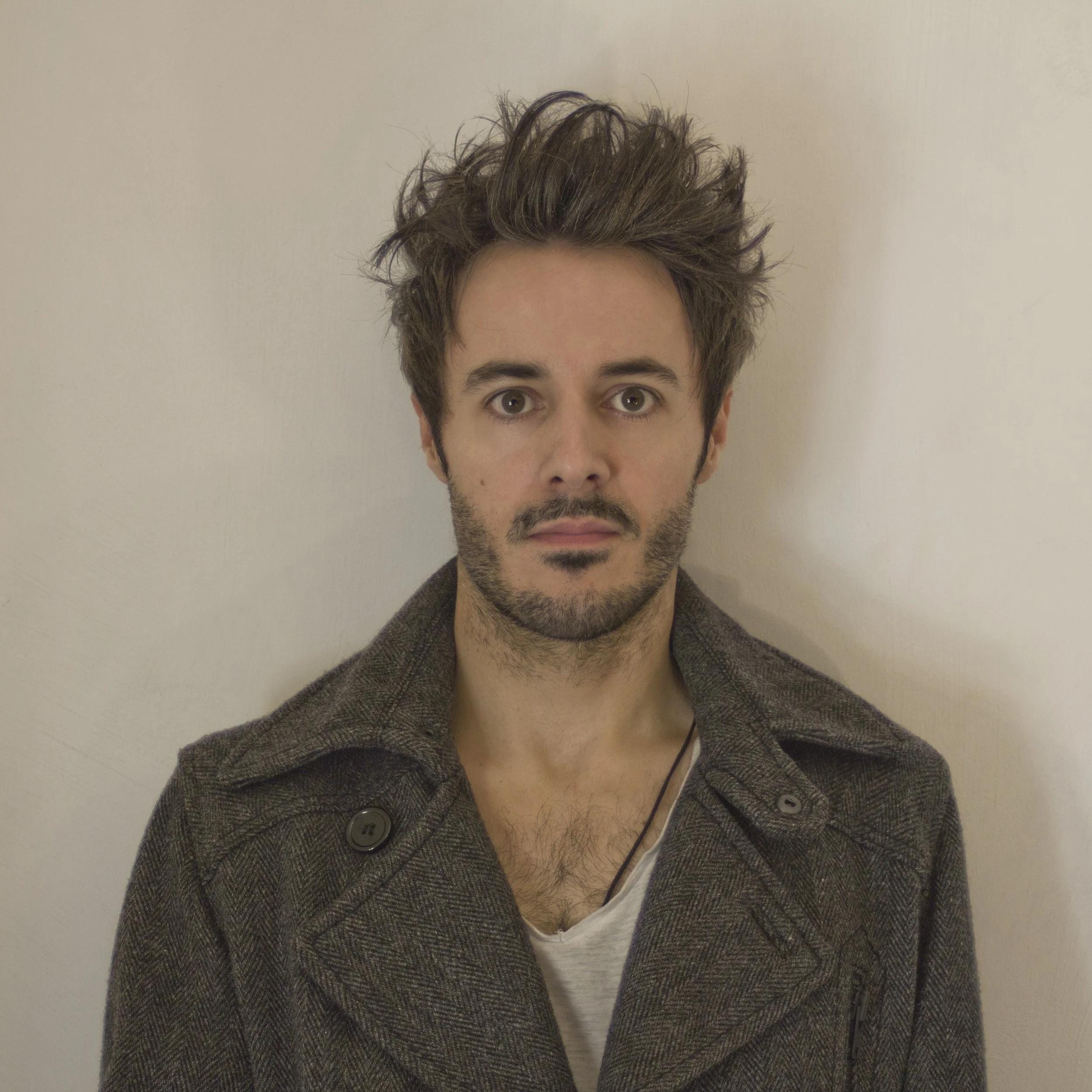 James Kennedy, the singer and author from Wales posing in a long coat with spiky hair 