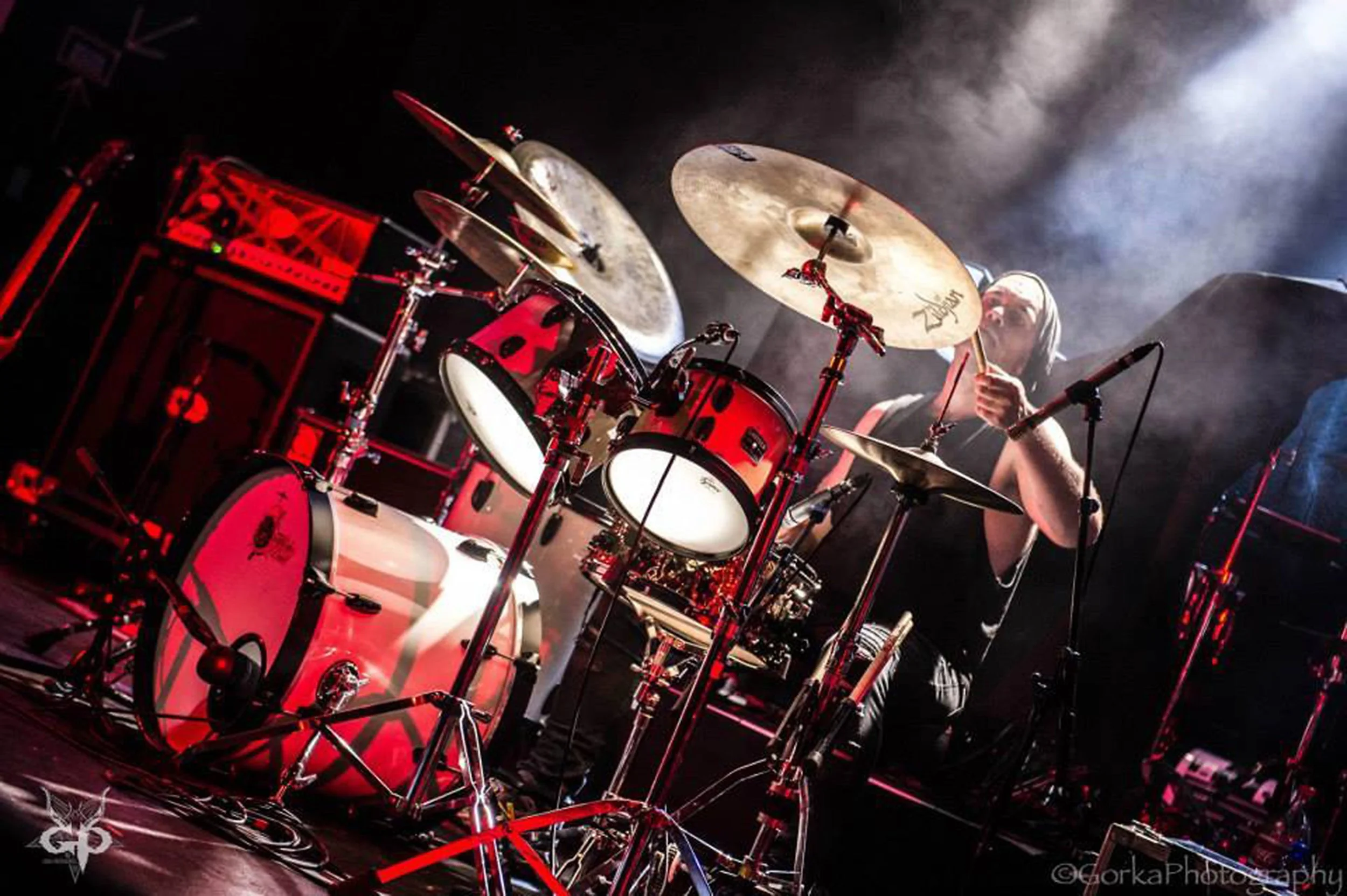 Glyn Bateman, the drummer in the rock band 'Kyshera' playing drums at a concert in Switzerland with cool stage lights 