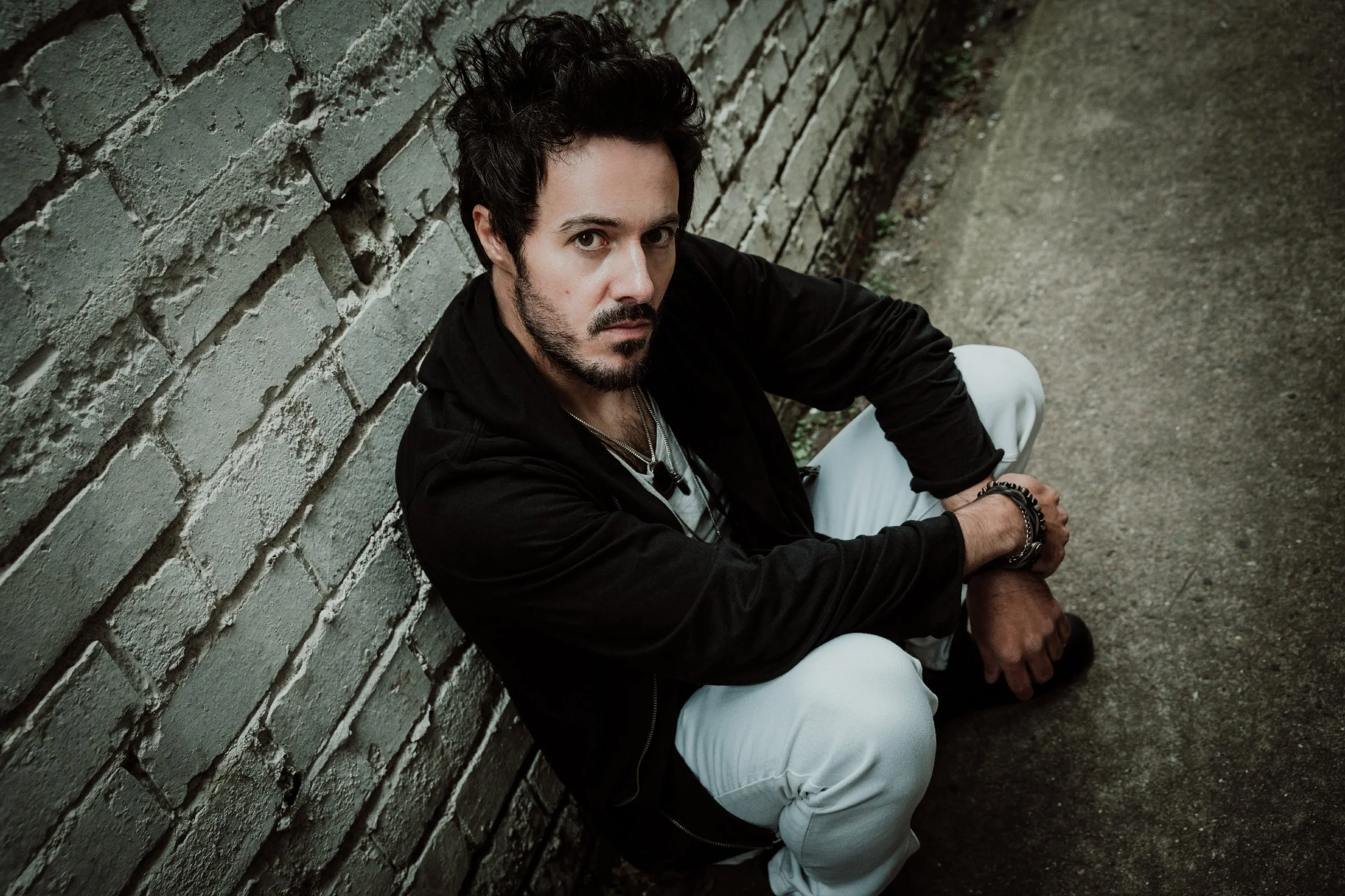 James Kennedy, the Welsh singer, author and podcaster sitting on the floor posing for a photoshoot with the band 'James Kennedy and The Underdogs'