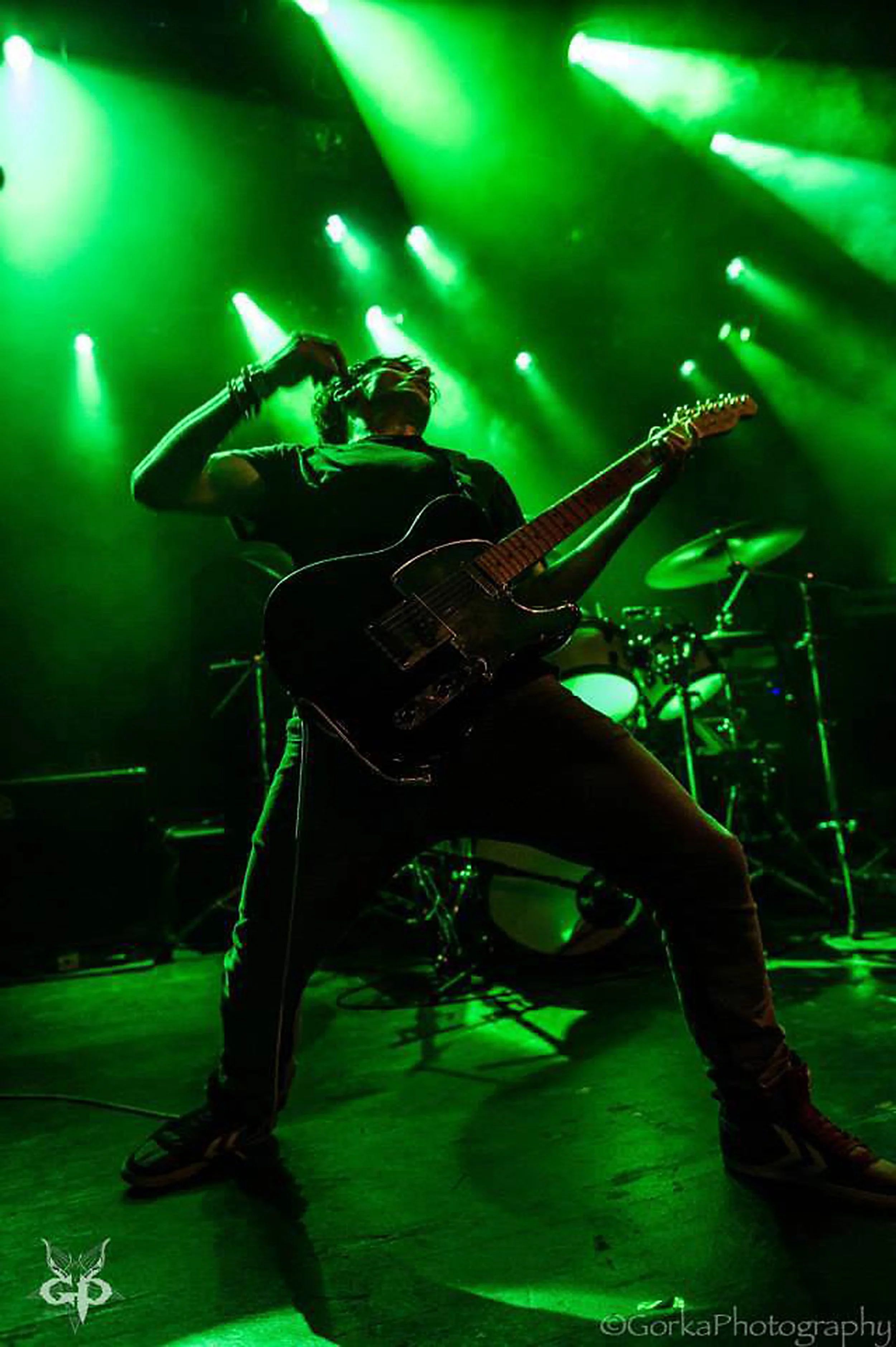 James Kennedy, the singer in the bands 'Kyshera' and 'James Kennedy and The Underdogs' playing guitar on stage with Kyshera in Switzerland. This is the original photo that was used for the 'Noise Damage' book cover