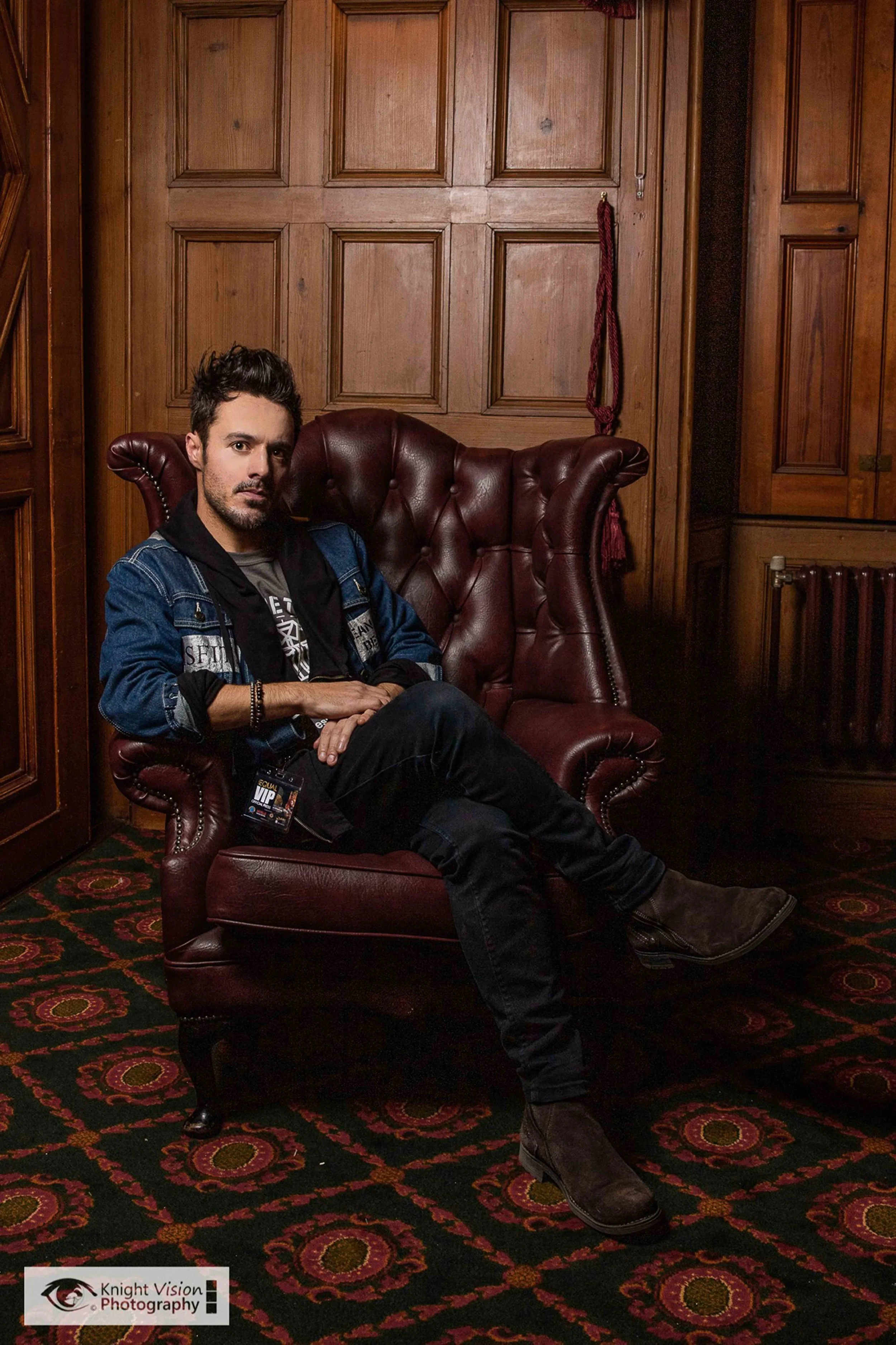 James Kennedy, the singer, author and podcaster from Wales posing in an arm chair backstage at a concert in Belfast