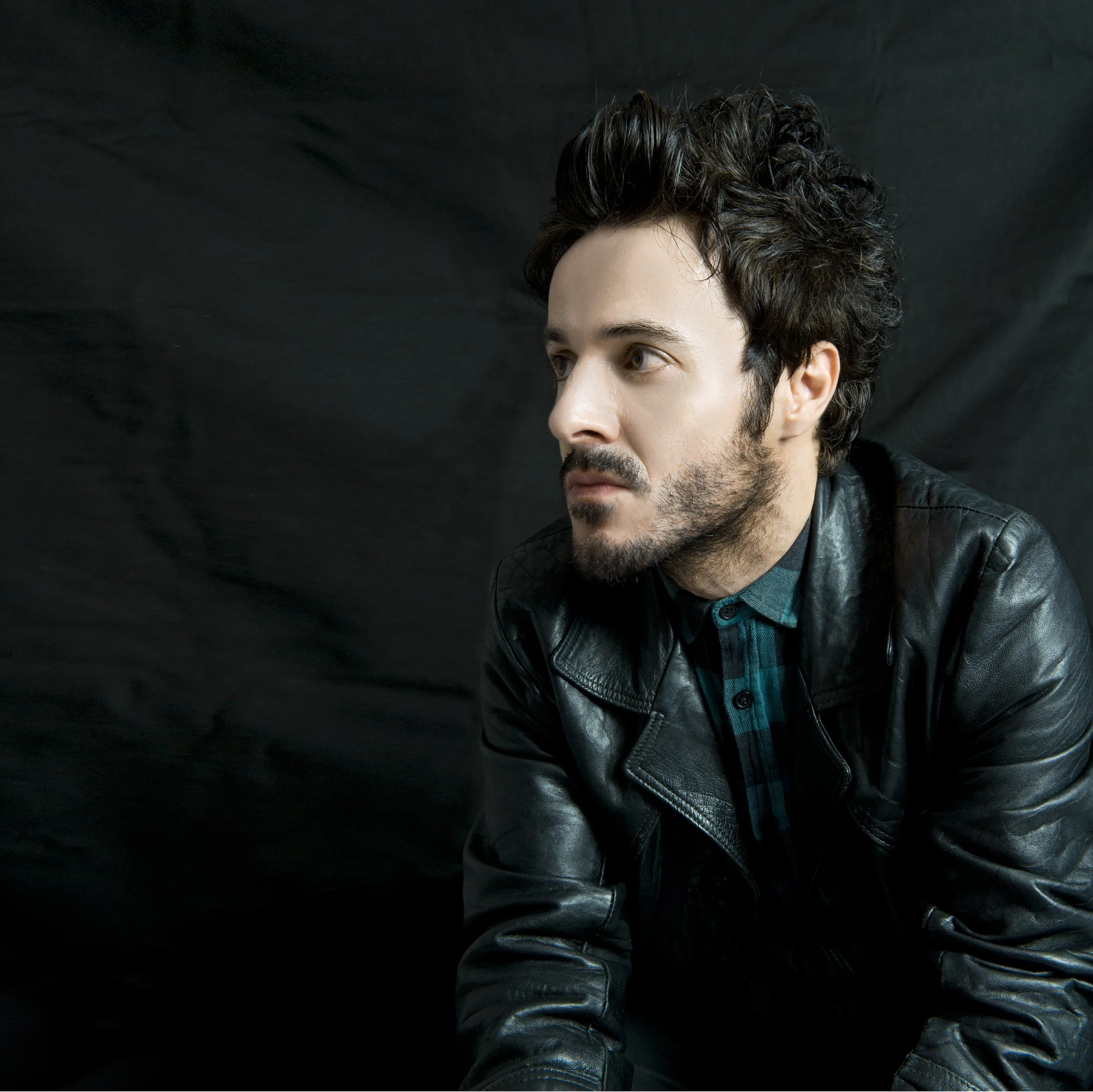 James Kennedy, the singer songwriter and author from Wales posing in a leather jacket with spikey hair
