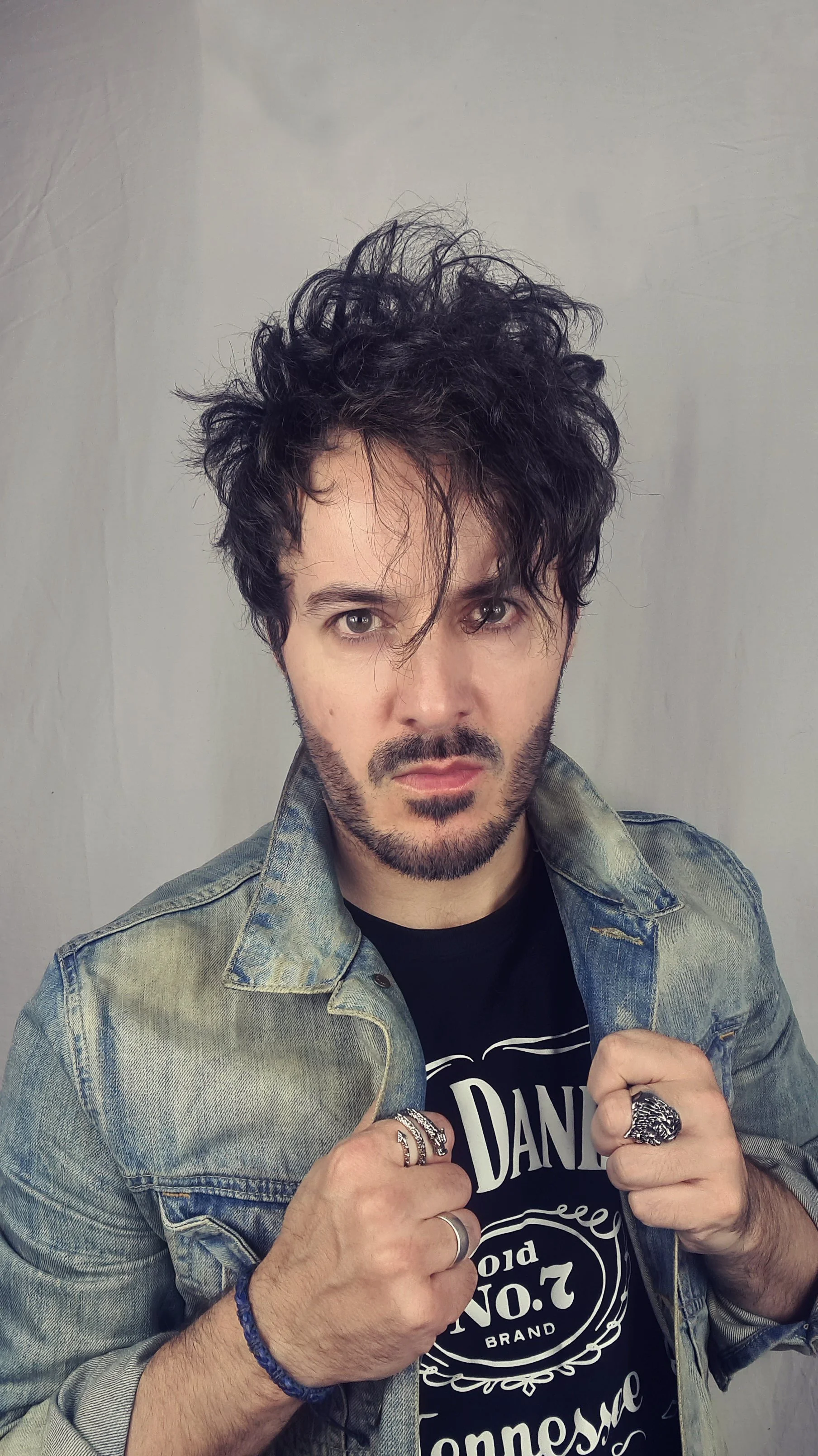 James Kennedy, author and singer in the band 'James Kennedy and The Underdogs' posing in a denim jacket with a long fringe hair hairstyle
