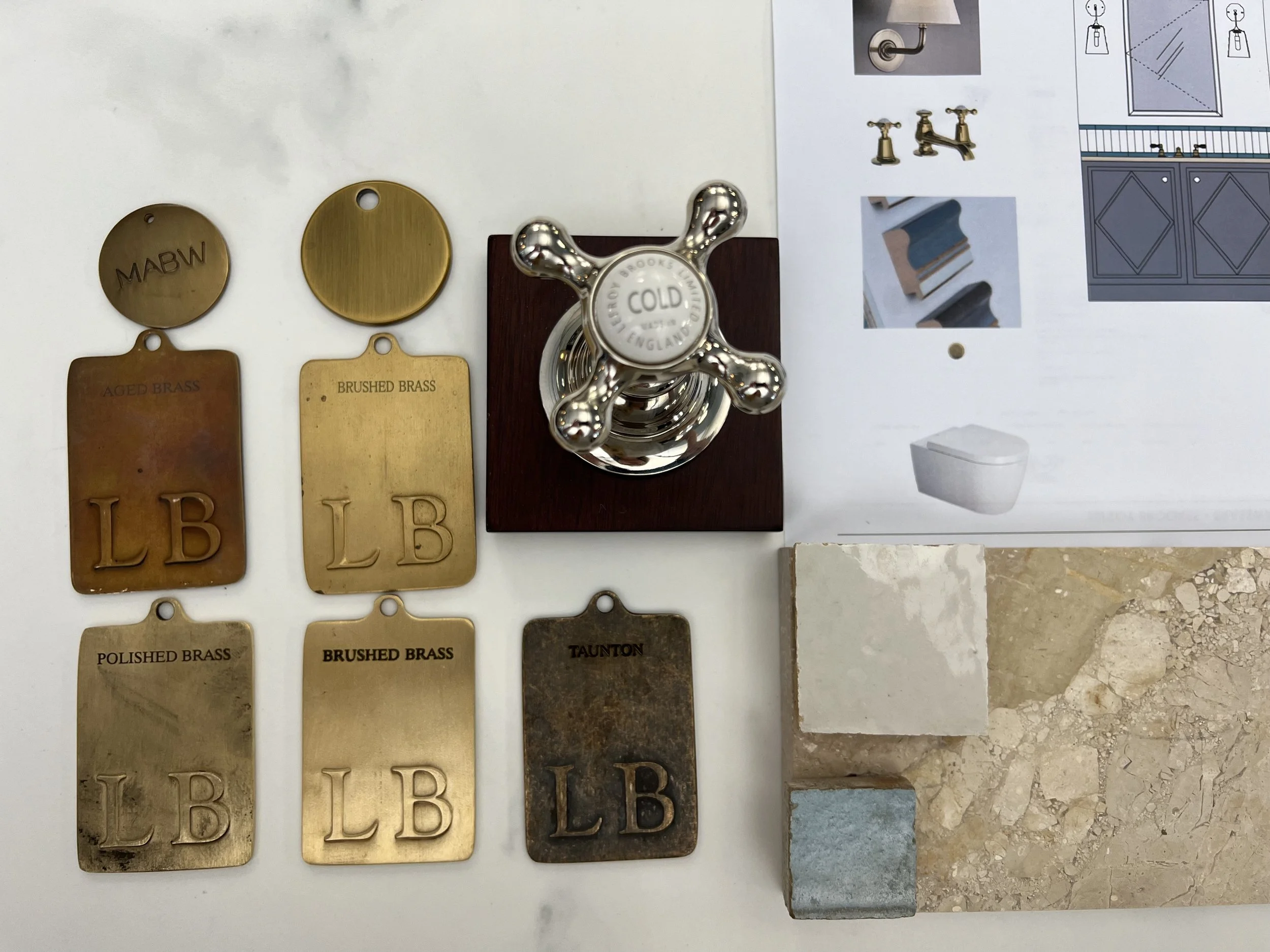 Sample of brass and stone material swatches, a faucet handle, and a bathroom illustration.