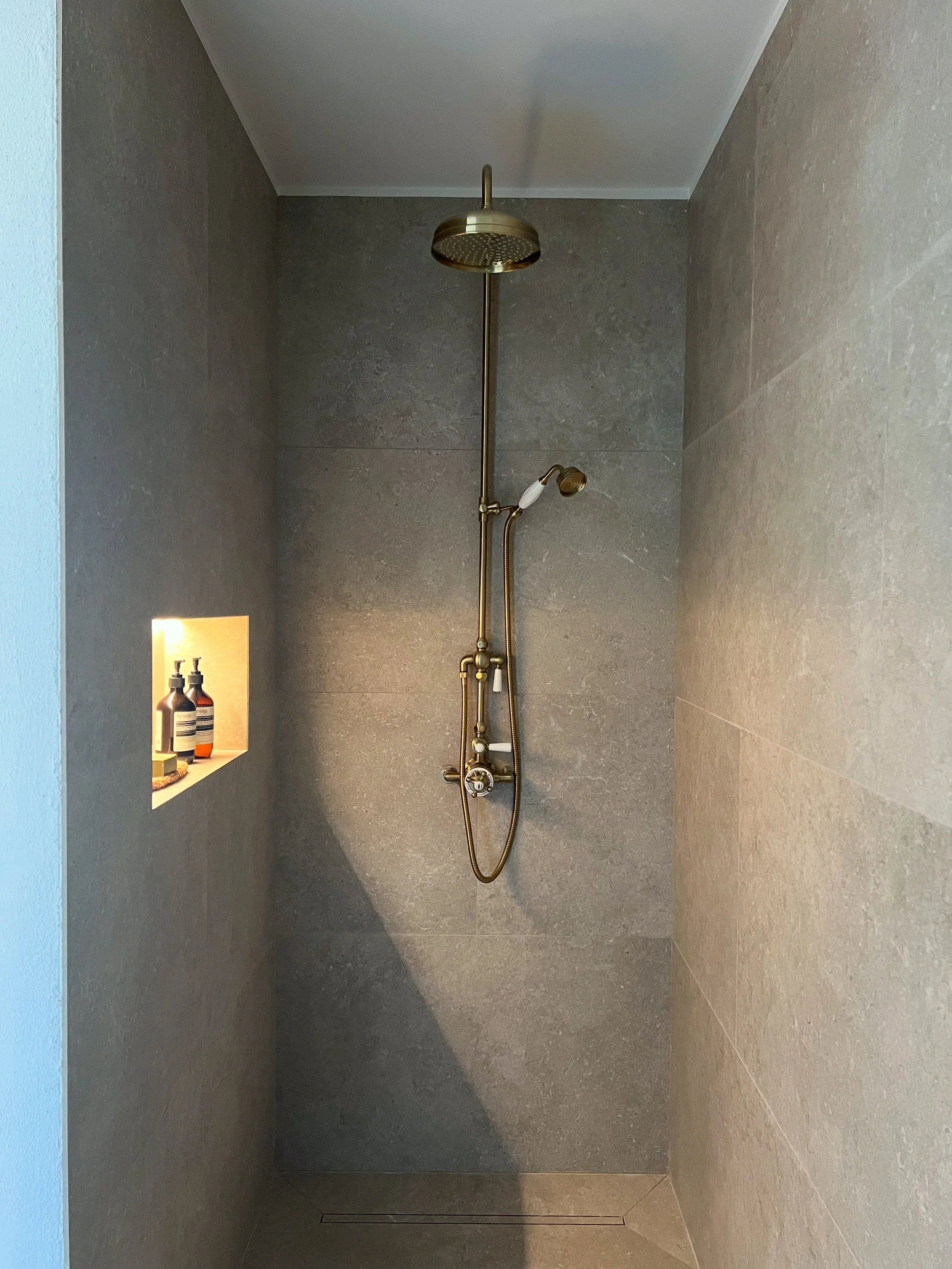 tiled shower, large format tile, niche, lighting, Aesop, luxury, brass
