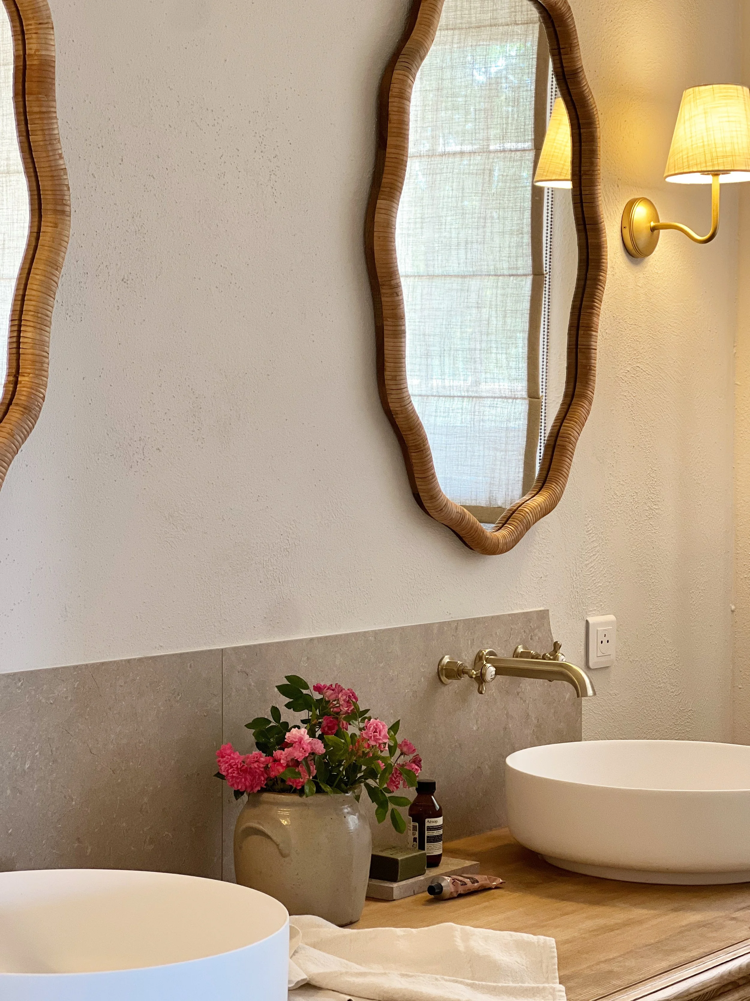 vanity area, white basins, stone splasback, flowers, scallop rattan mirrors, corston wall lights, luxurious space, calm, natural, zen, wellness