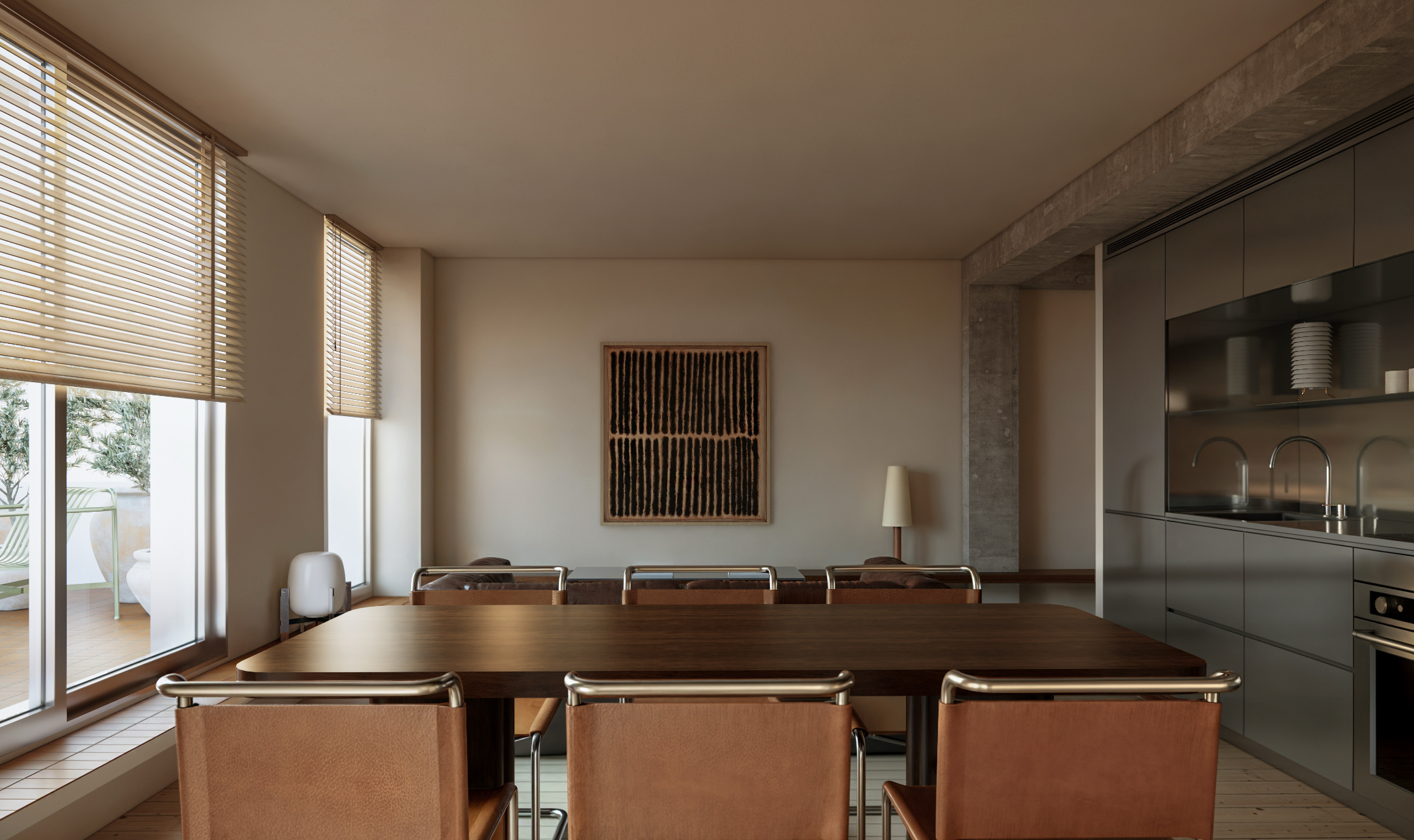 Interior of a modern dining room with a wooden table, brown chairs, large windows with blinds, and a beige wall with artwork, adjacent to a kitchen area with grey cabinets and a stainless steel sink.