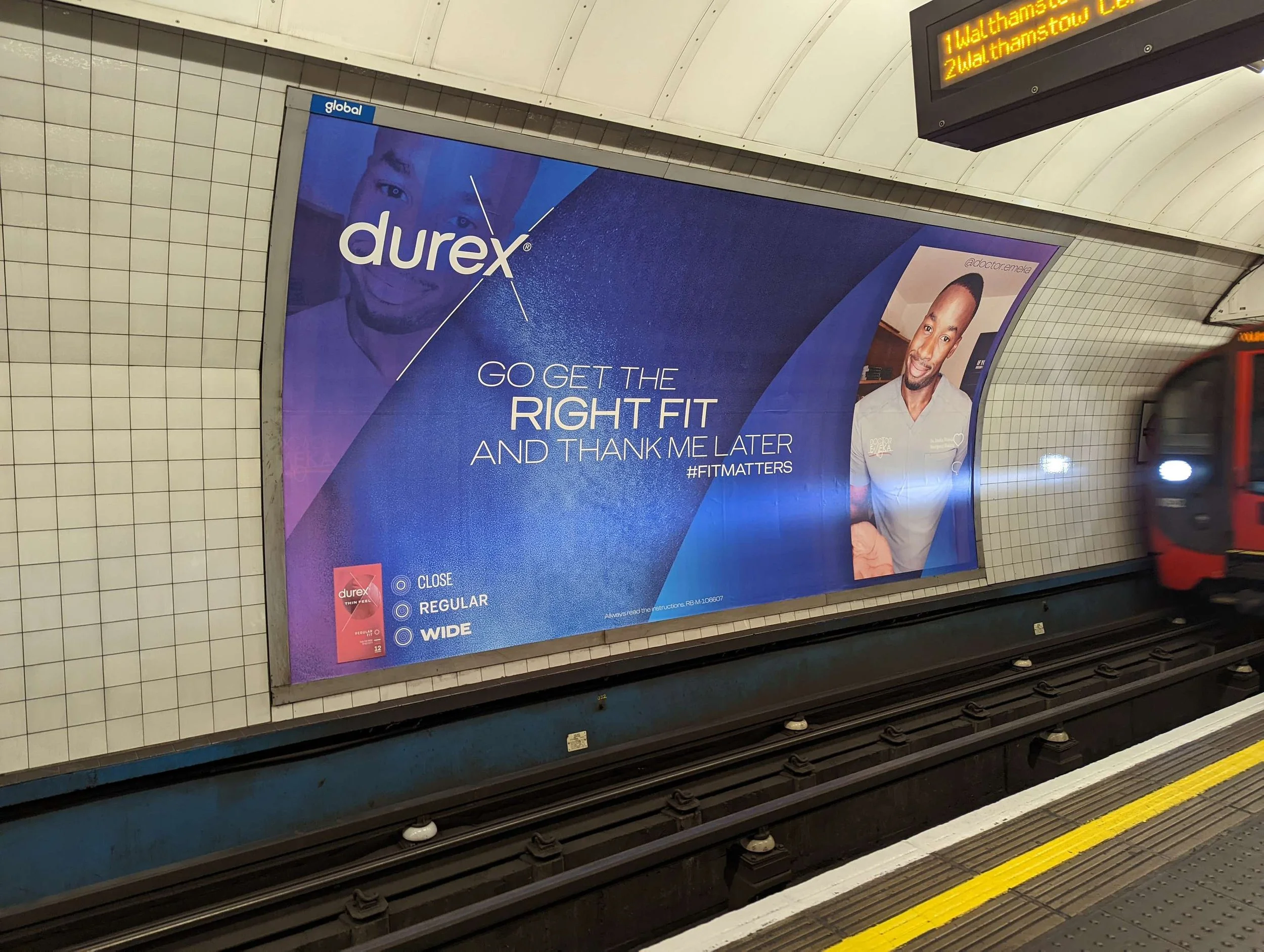 Advertisement on a subway platform for Durex condoms, featuring a smiling man and the text "Go get the right fit and thank me later."