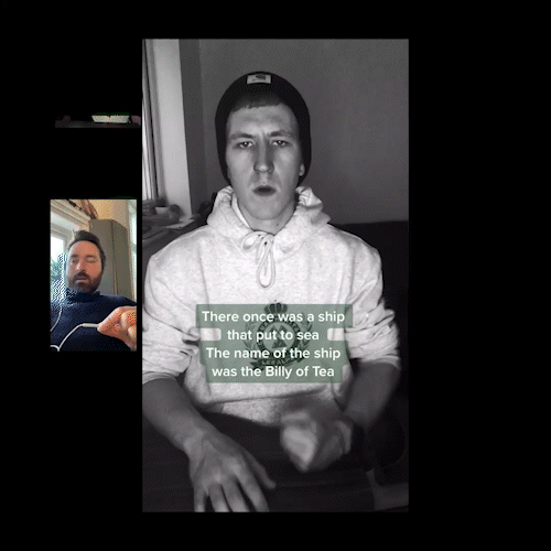 A young man wearing a beanie and grey hoodie with white drawstrings. There is a caption on the screen that reads, "There once was a ship that put to sea. The name of the ship was the Billy of Tea."
