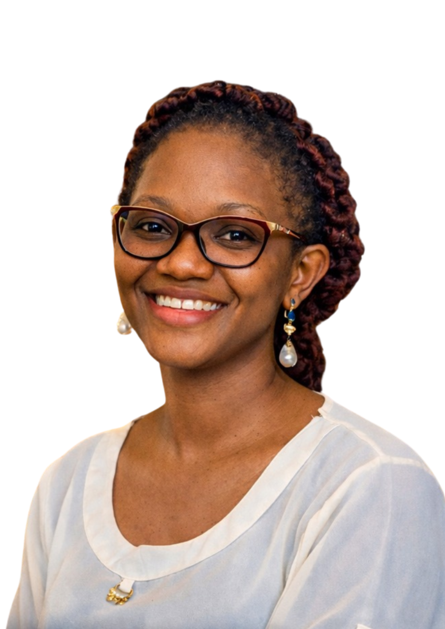 A woman with dark skin, braided red hair, glasses, and pearl earrings, smiling and wearing a white dress with a small brooch on the neckline.
