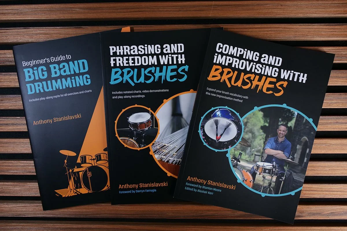 Stack of three books written by Anthony Stanislavski: Beginner’s Guide to Big Band Drumming; Phrasing and Freedom with Brushes; and Comping and Improvising with Brushes. All three book covers have drum set imagery on them.