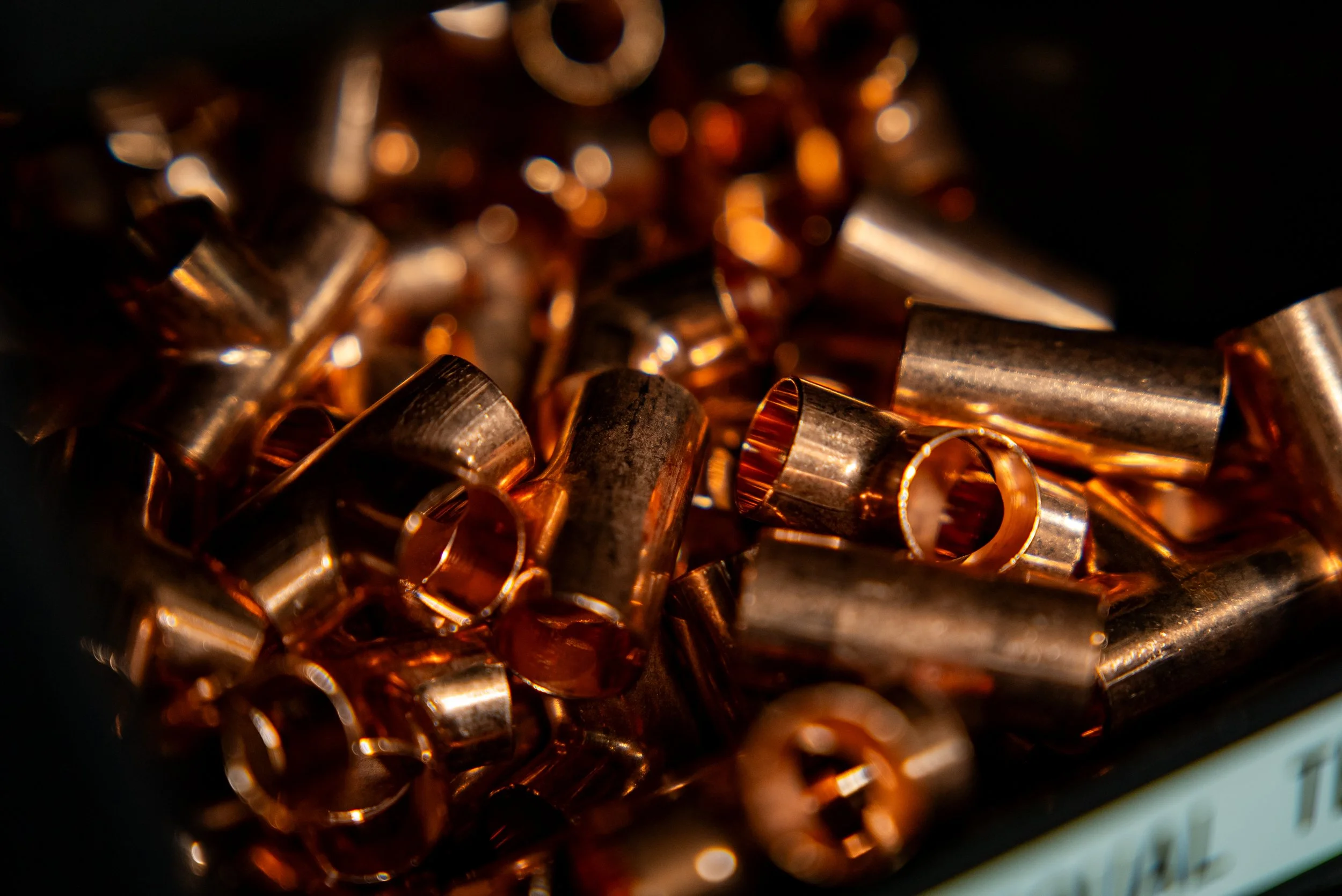 Close-up of copper crimp connectors in a container.