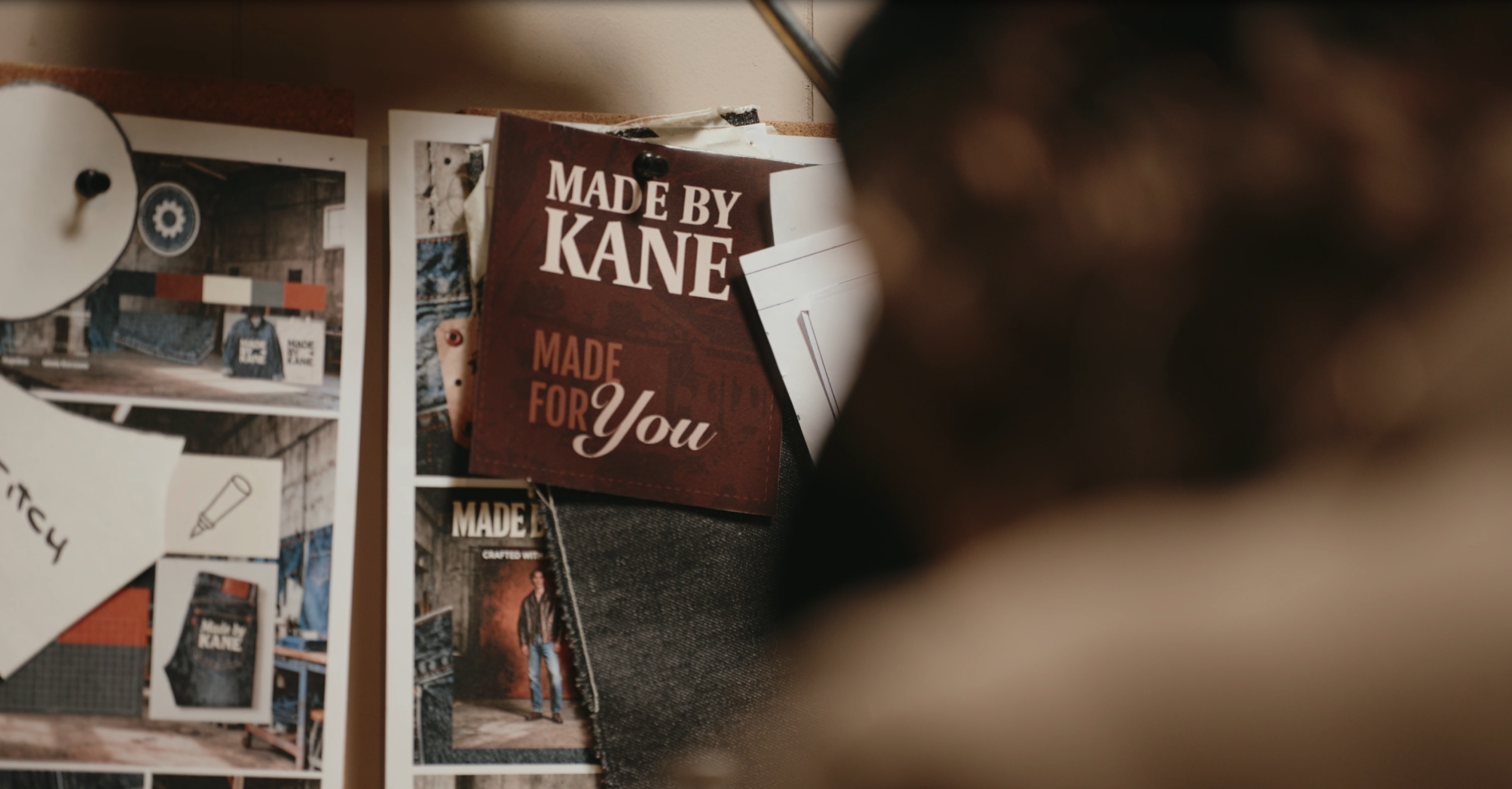 A bulletin board with photos, notes, and a brochure titled 'Made by Kane, Made for You.'