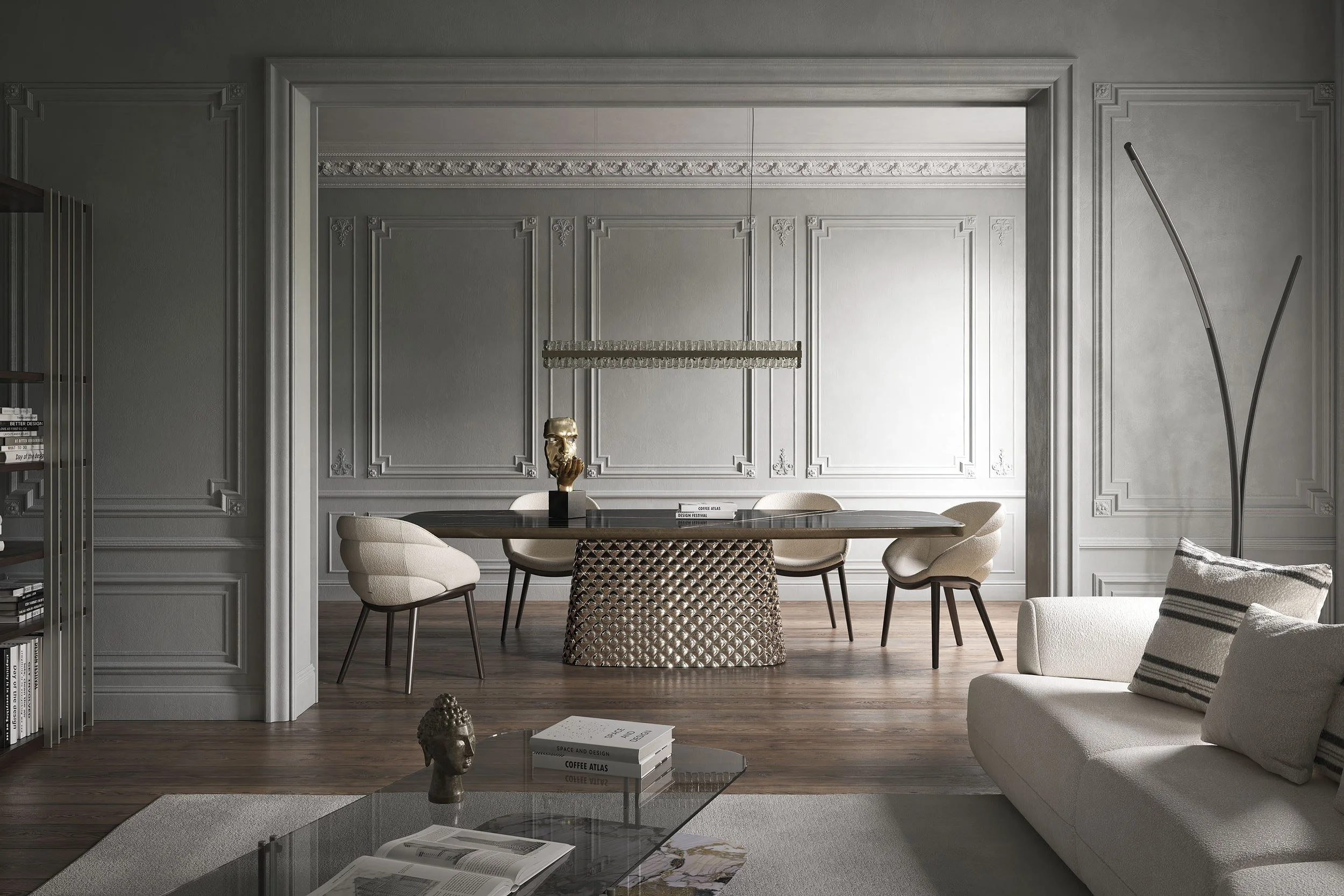 Modern dining room with a gray paneled wall, a long dark wood table, and six beige upholstered chairs. Decor includes a gold sculpture, books, and a hanging light fixture.