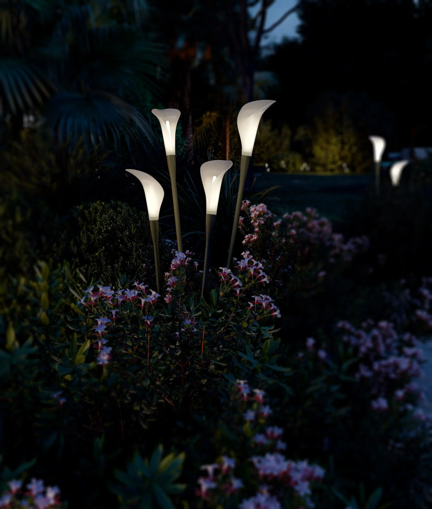 Outdoor garden at night with illuminated flower-shaped pathway lights among flowering bushes.