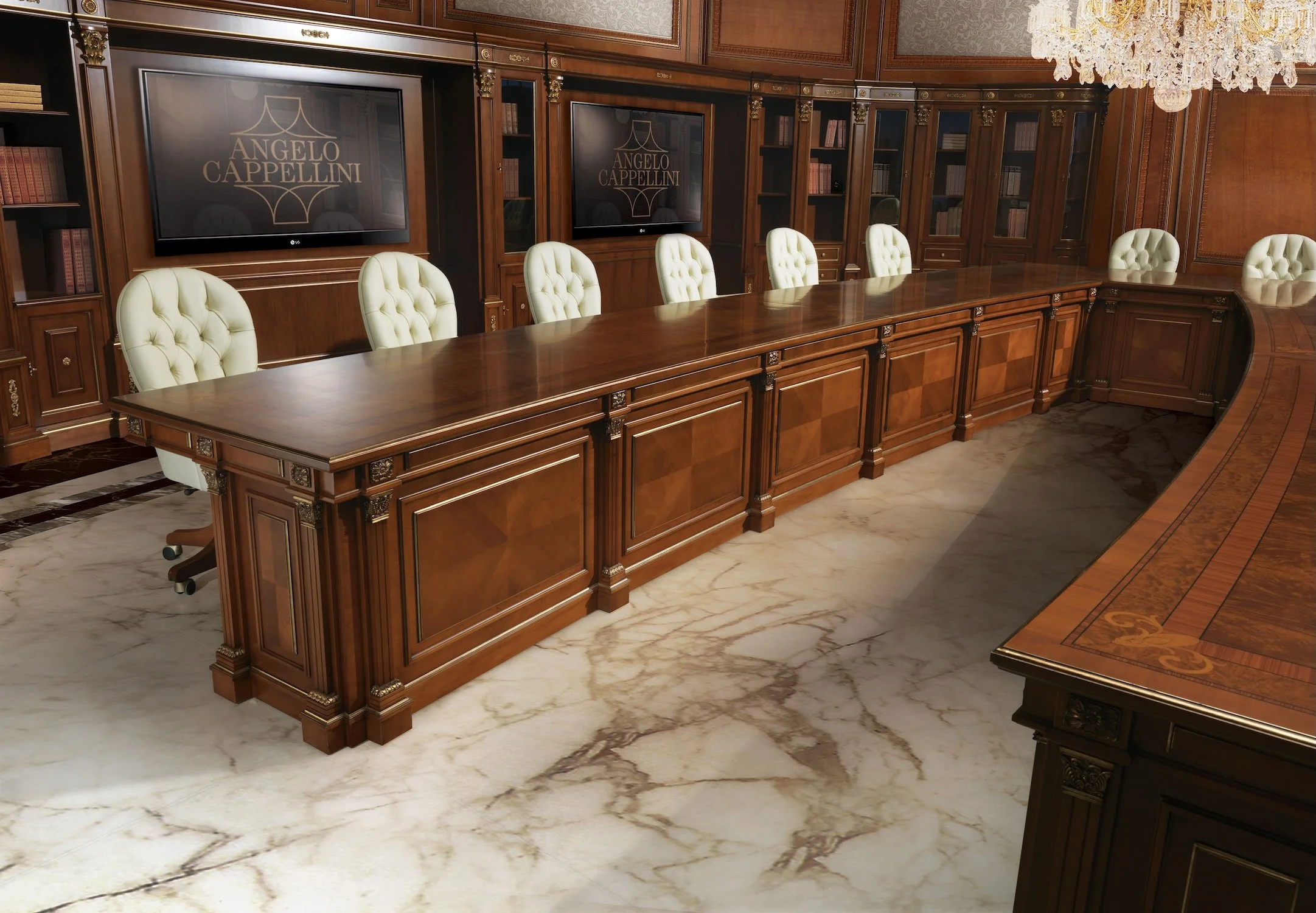 A luxurious conference room with wood paneling, cream upholstered chairs, large wooden table, marble floor, two large screens displaying 'Angelo Cappellini', and a chandelier.