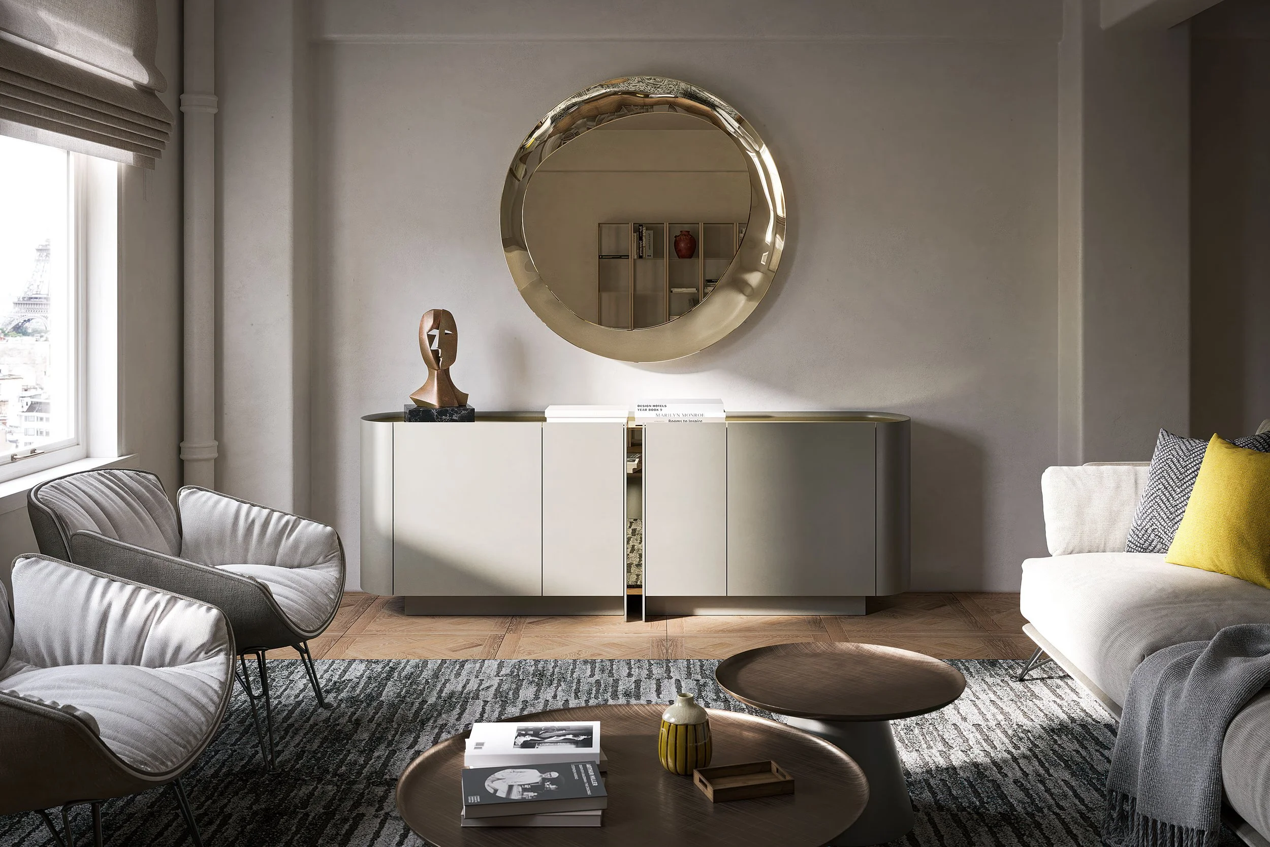 Modern living room with white sofa, armchair, wooden coffee tables, abstract sculpture, round mirror, and books on a rug.