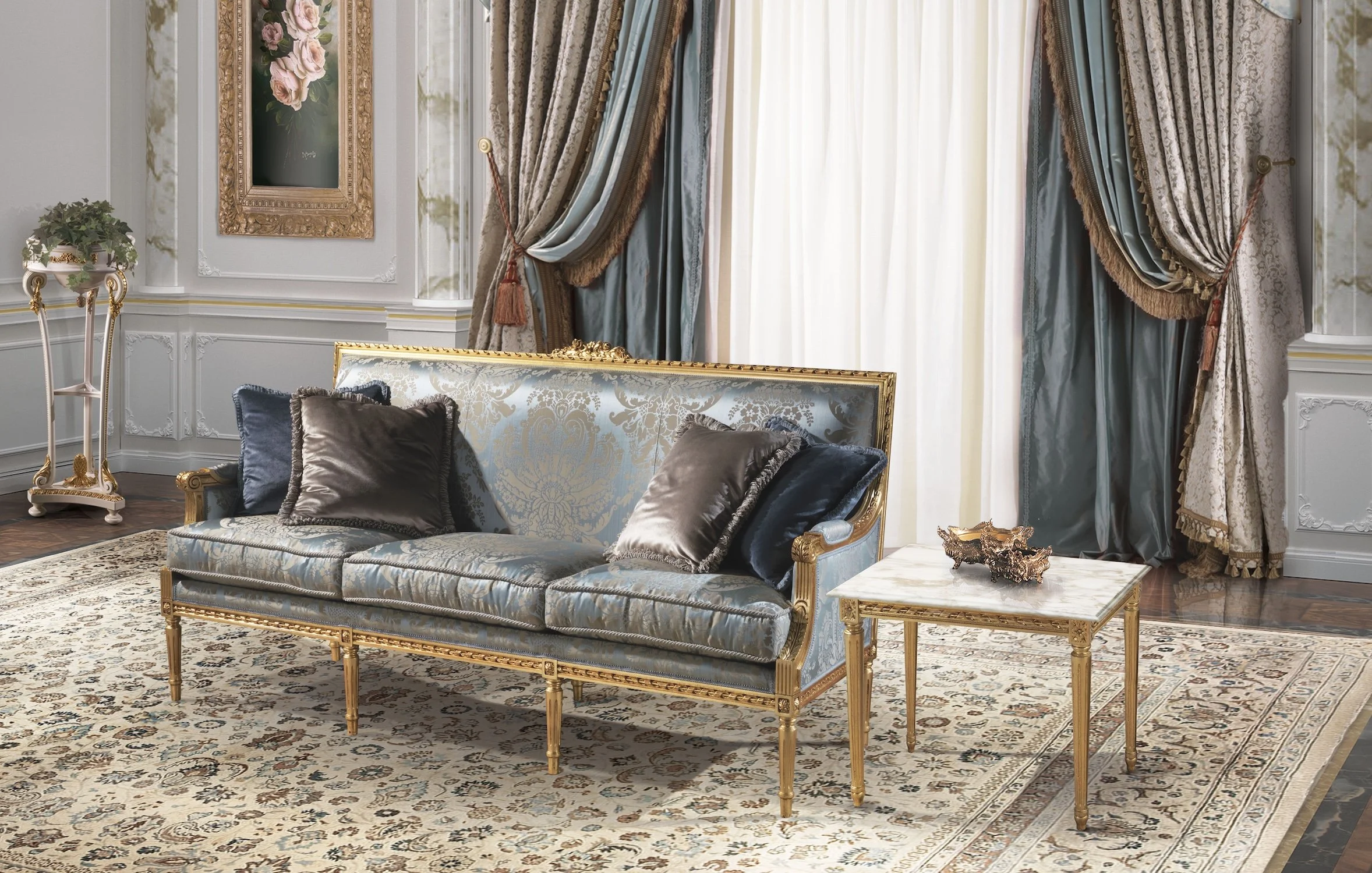 Elegant living room with a blue and gold sofa, dark pillows, a marble-top side table with decorative items, ornate curtains, a framed floral painting, a patterned rug, and a white wall with molding.