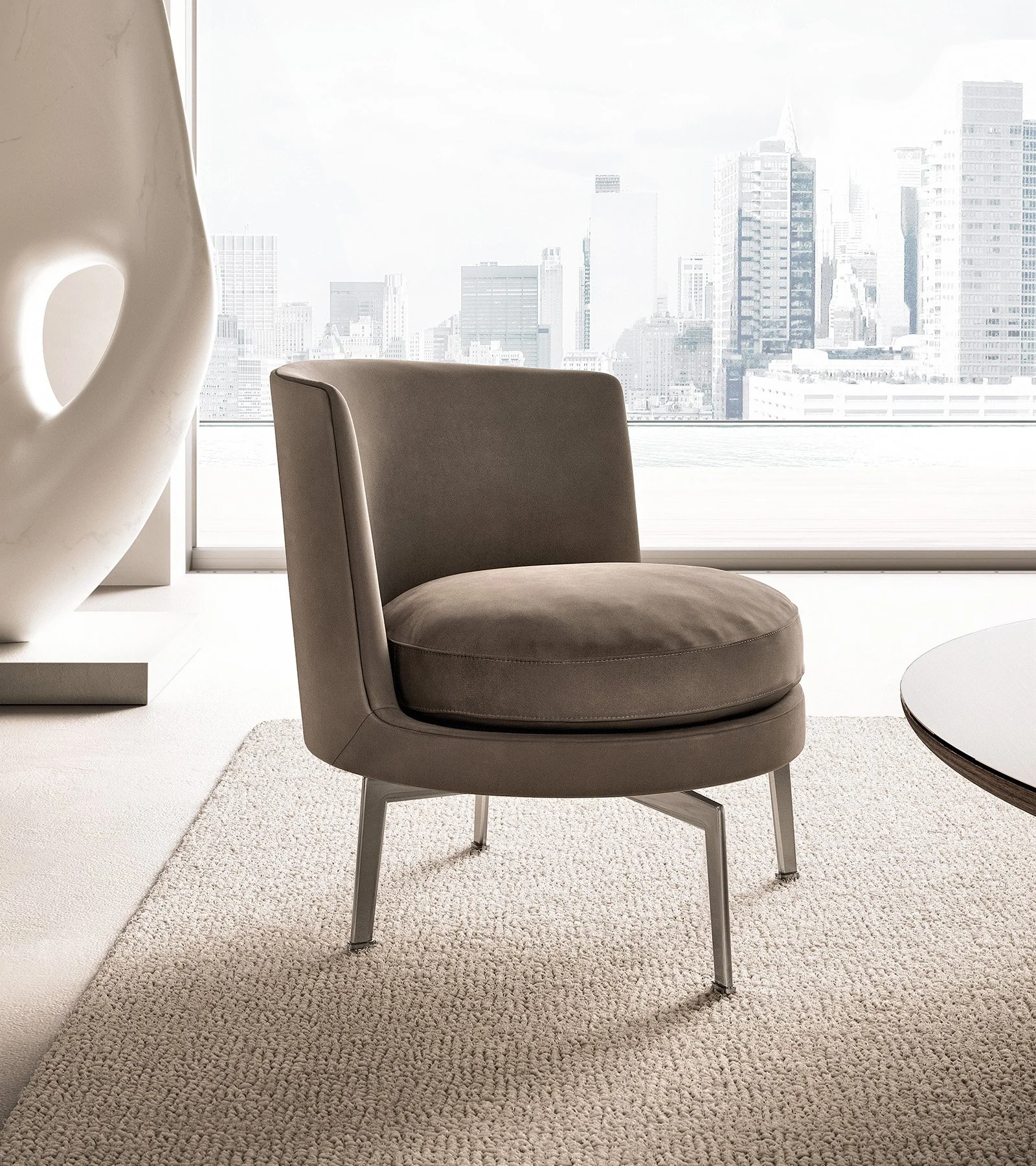 Modern living room with a gray armchair, a large window with a city skyline view, a white sculpture on the left, and a round white table on the right.
