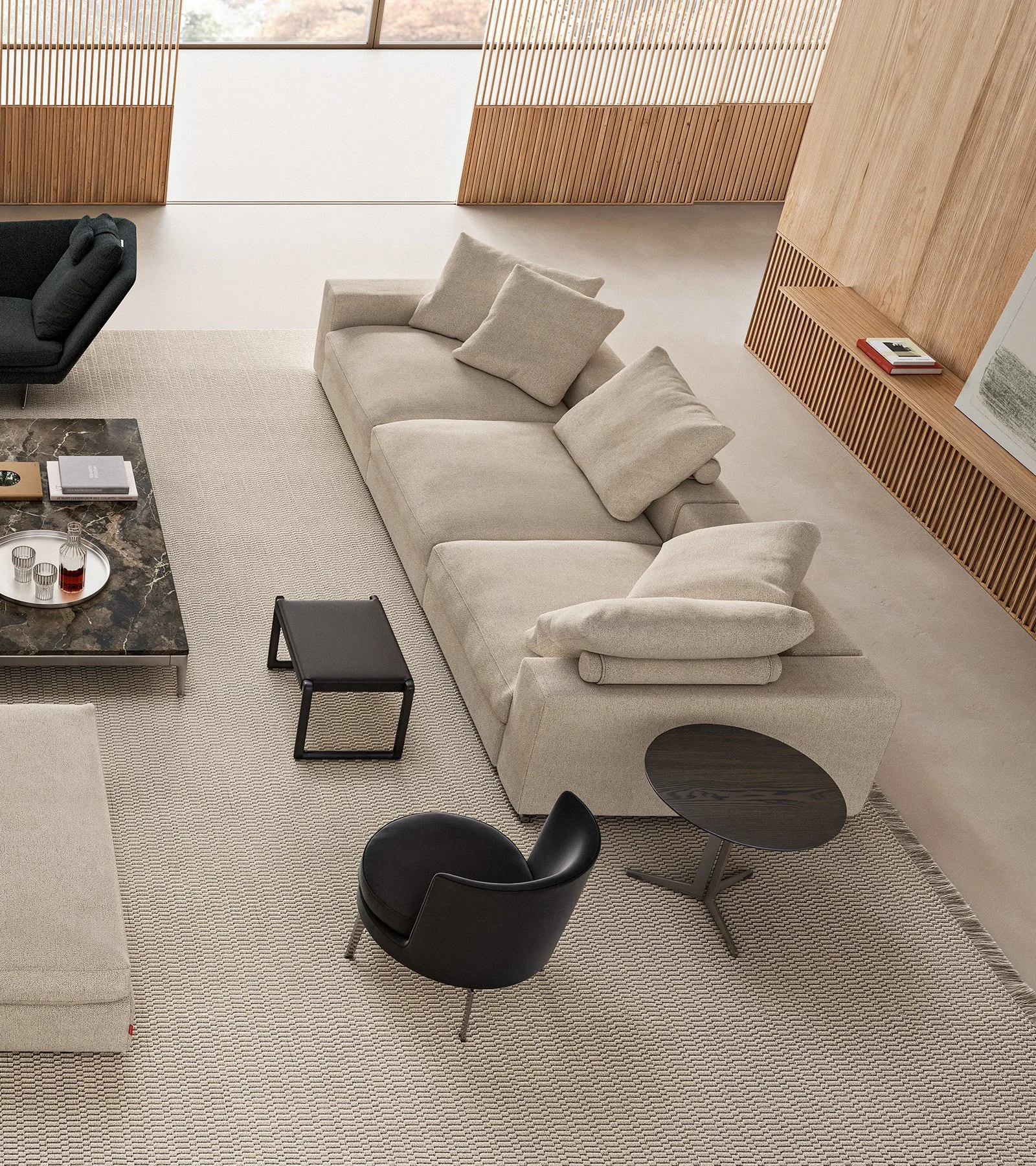 Interior of a modern living room with a beige sofa, black armchair, small black side table, marble coffee table, and beige carpet, with wooden wall panels and books and artwork.