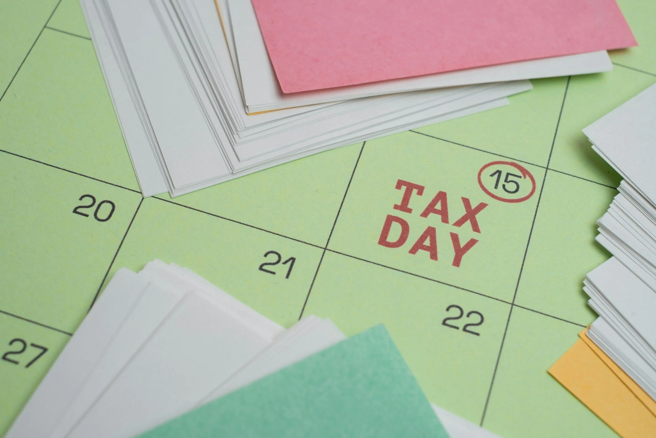 Close-up of a Monopoly game board with stacks of paper money on the 'Tax Day' space.