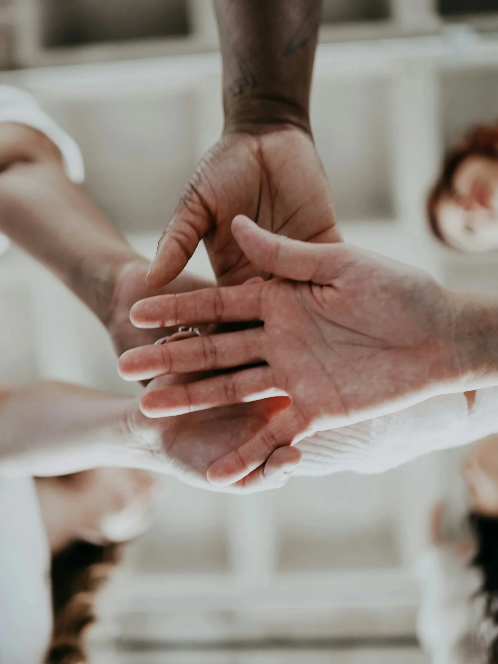 Two hands gently holding each other in a delicate embrace, with a blurred background.