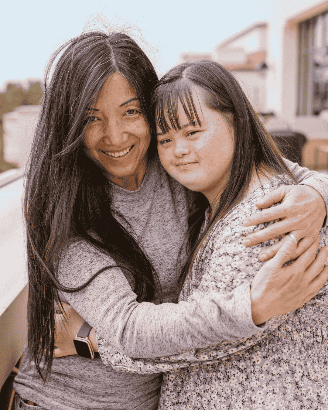 a woman hugs a young woman with learning disabilities