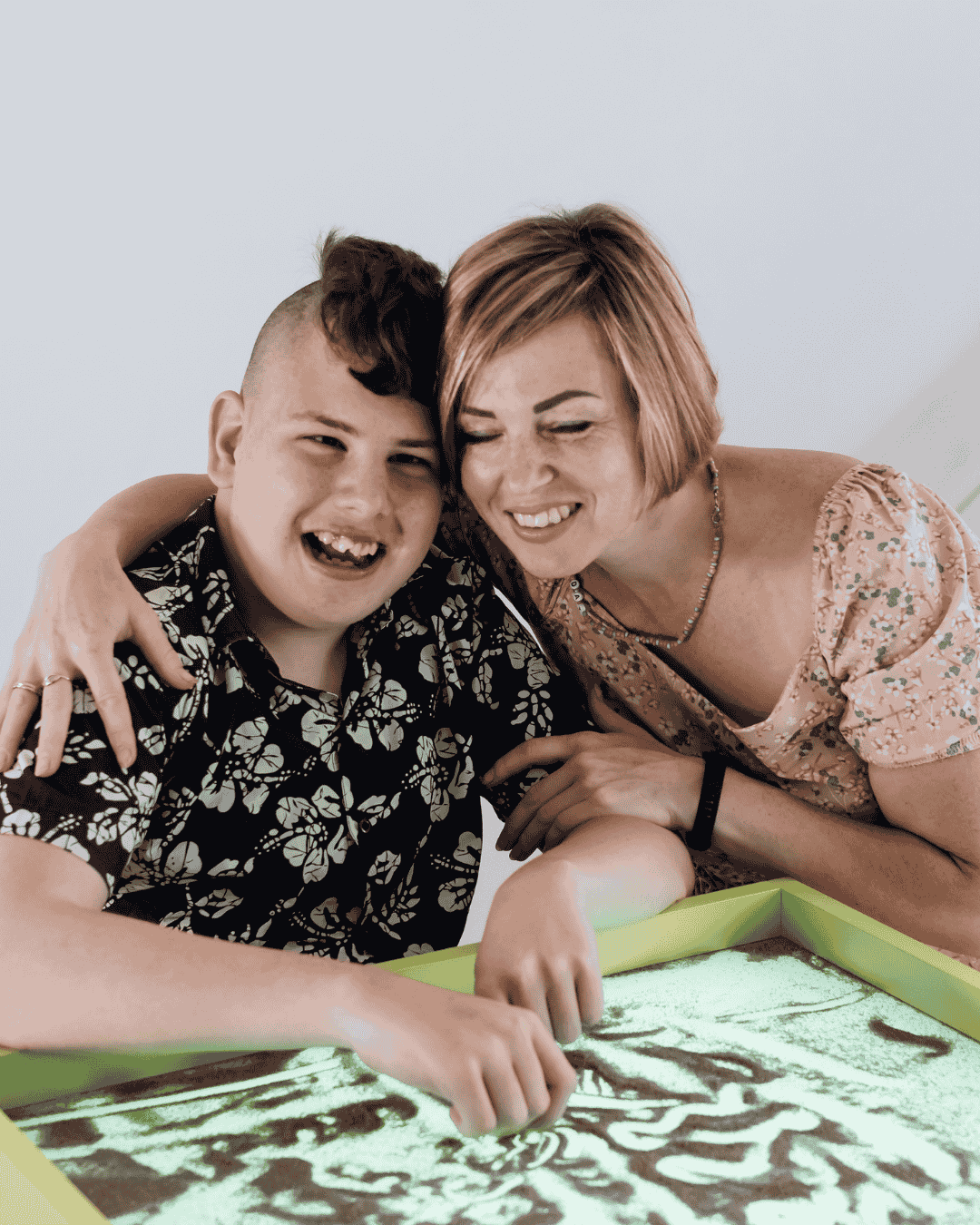 a woman hugs a young man with learning disabilities