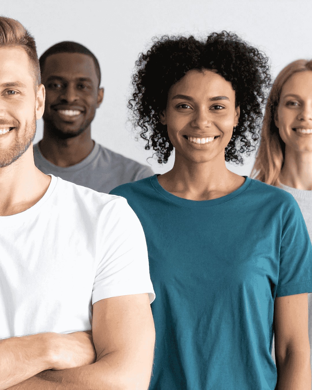 a group of friendly professionals in the care industry stand side by side and smile at the camera