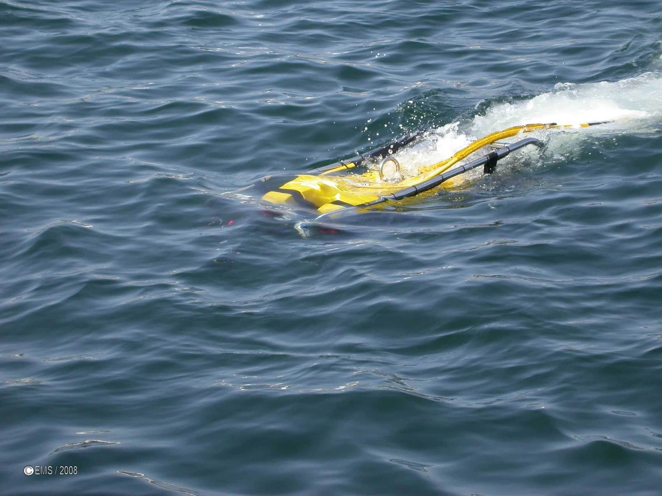 Yellow submarine-like object floating in water, partially submerged.
