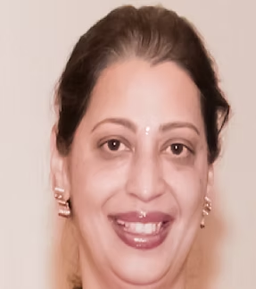 Close-up of a woman smiling, with earrings and traditional makeup, against a plain background.