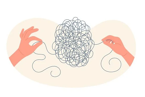 Two hands holding a tangled ball of string with loose ends on a plain background.