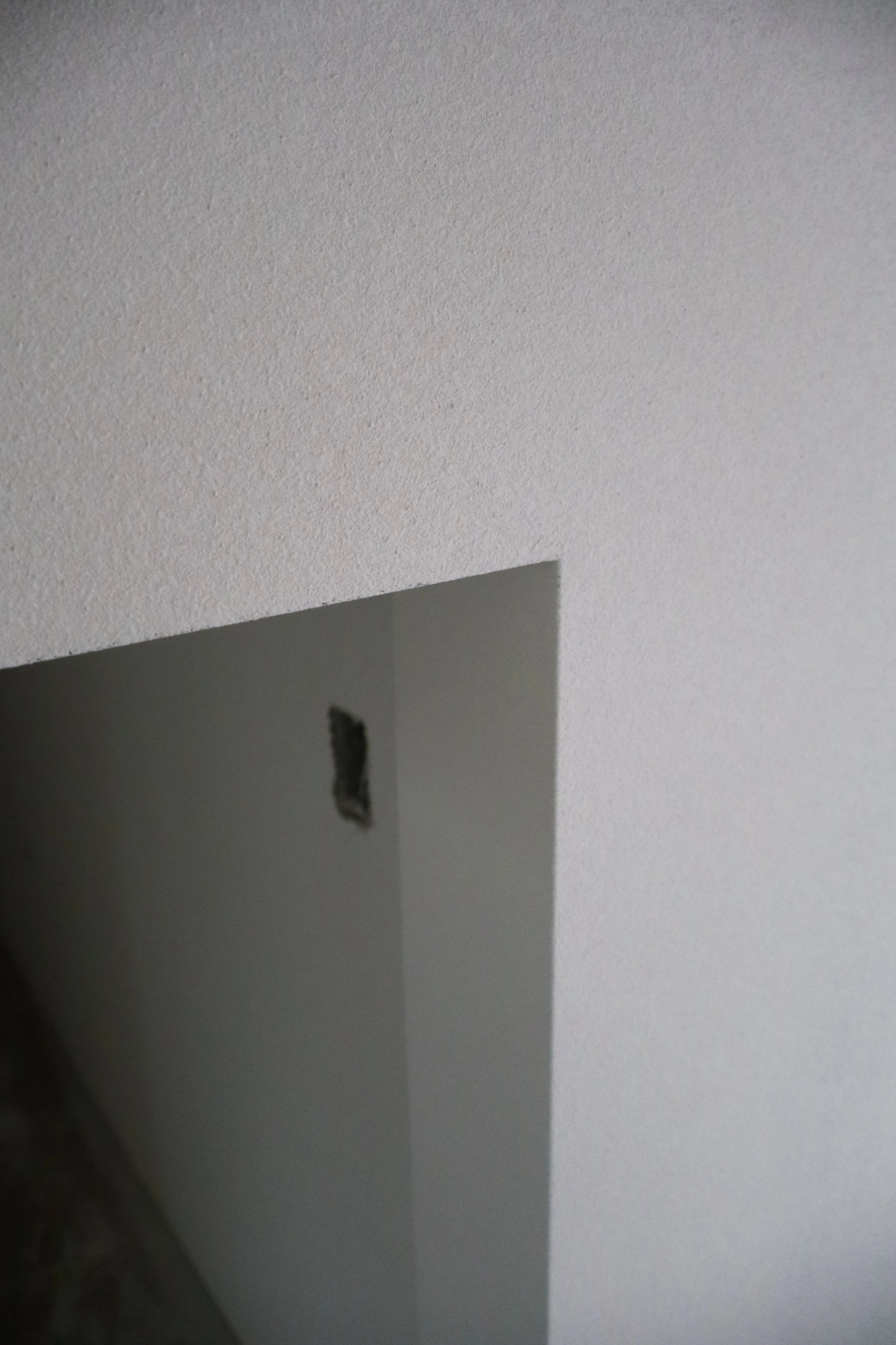 Photo of a drywall with a cutout and an electrical box hole.