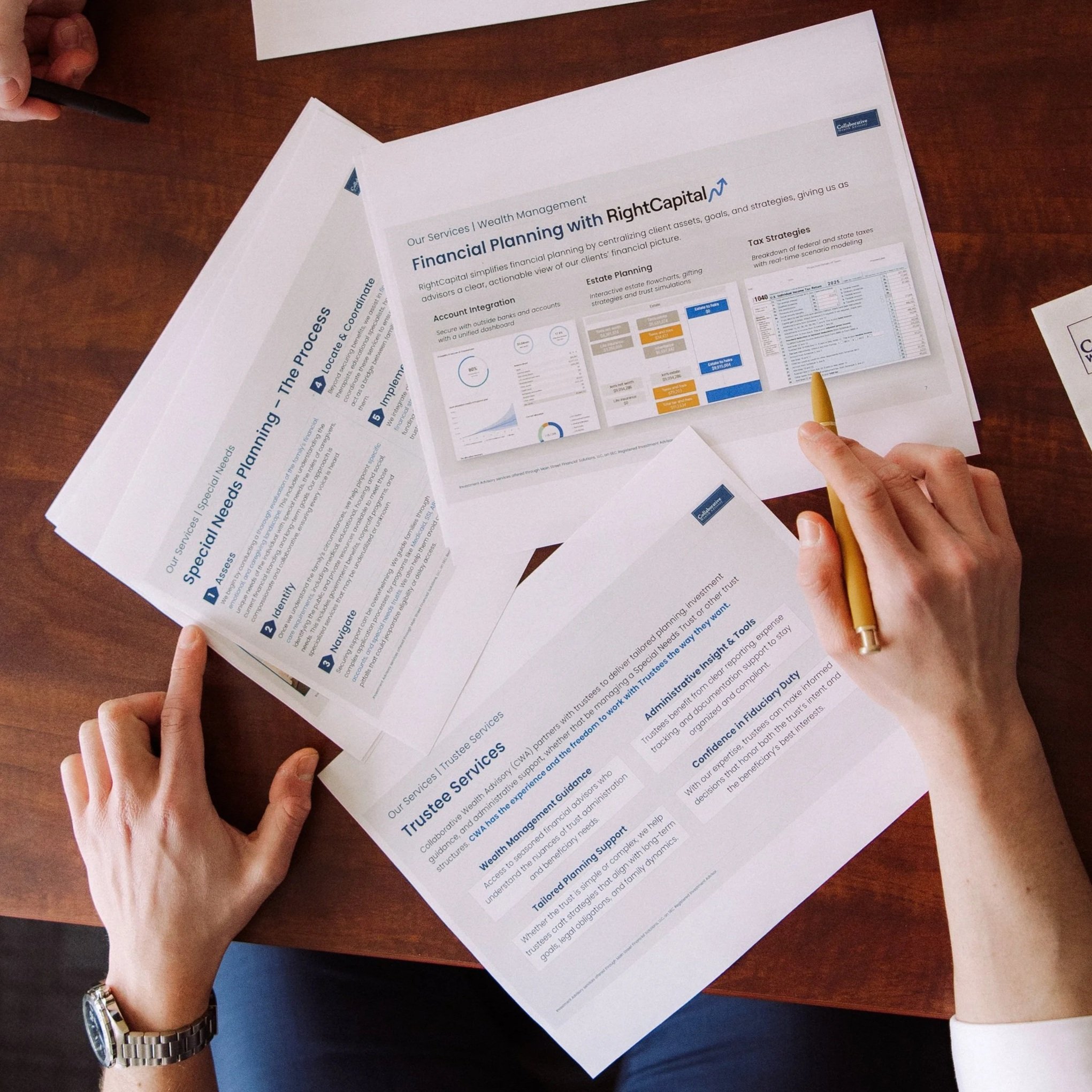 Person holding a yellow pen over financial planning documents on a wooden table, with papers containing charts, graphs, and text related to wealth management and trustee services.