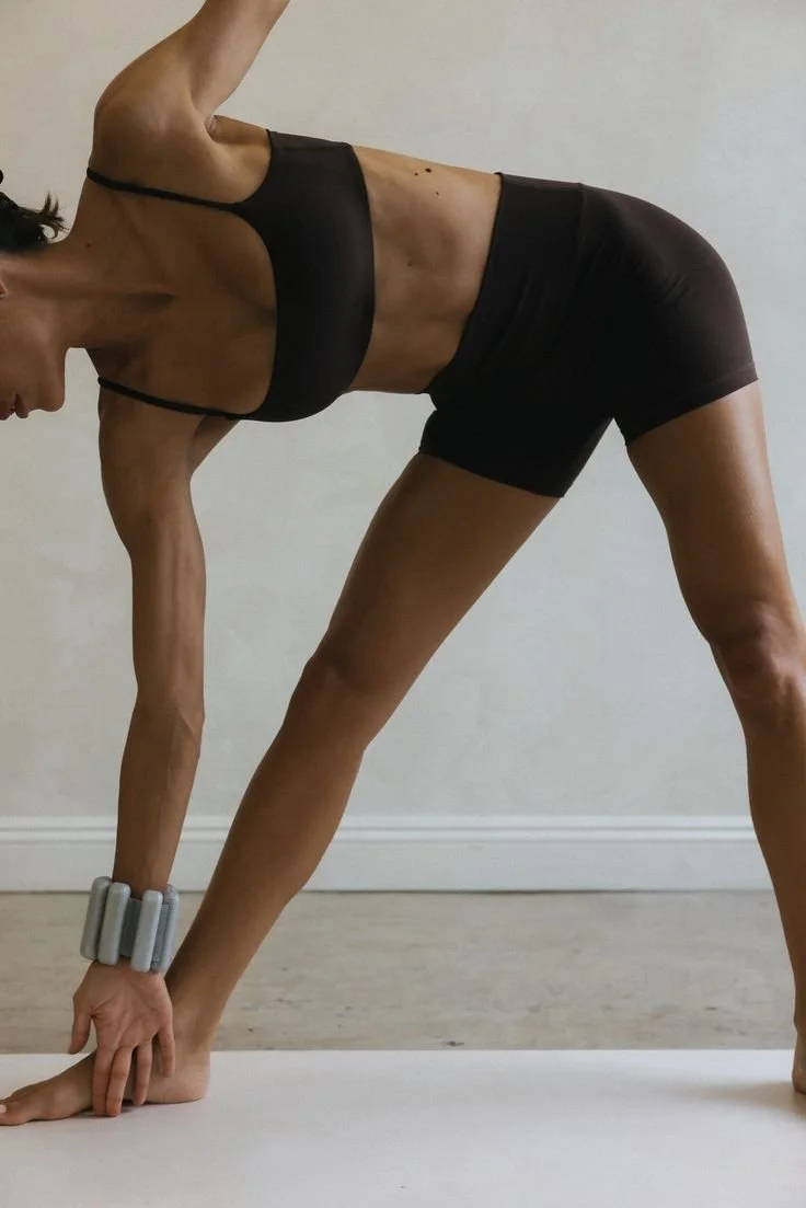 Žena cvičící pilates oblečená v espresso hnědém kompletu na pilates