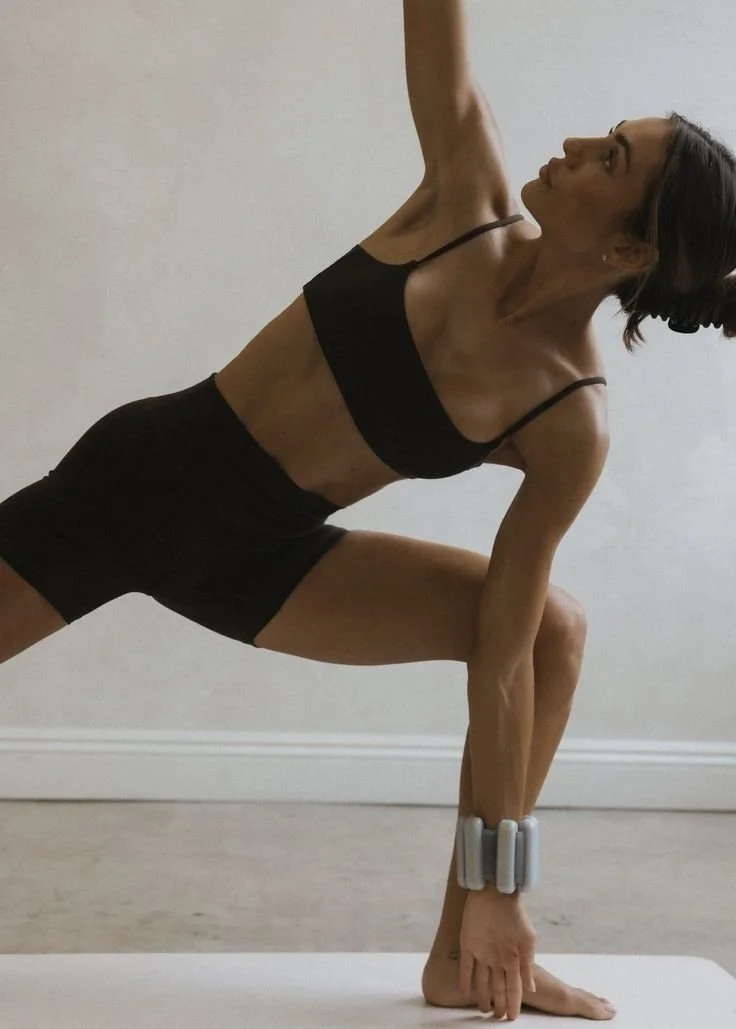 Žena cvičící pilates oblečená v espresso hnědém kompletu na pilates