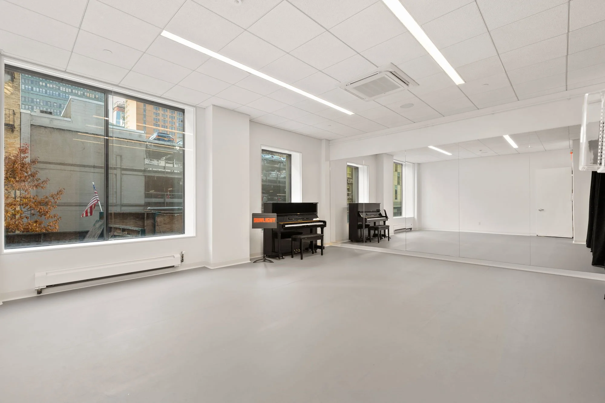 Medium sized studio with windows, marley floors and piano