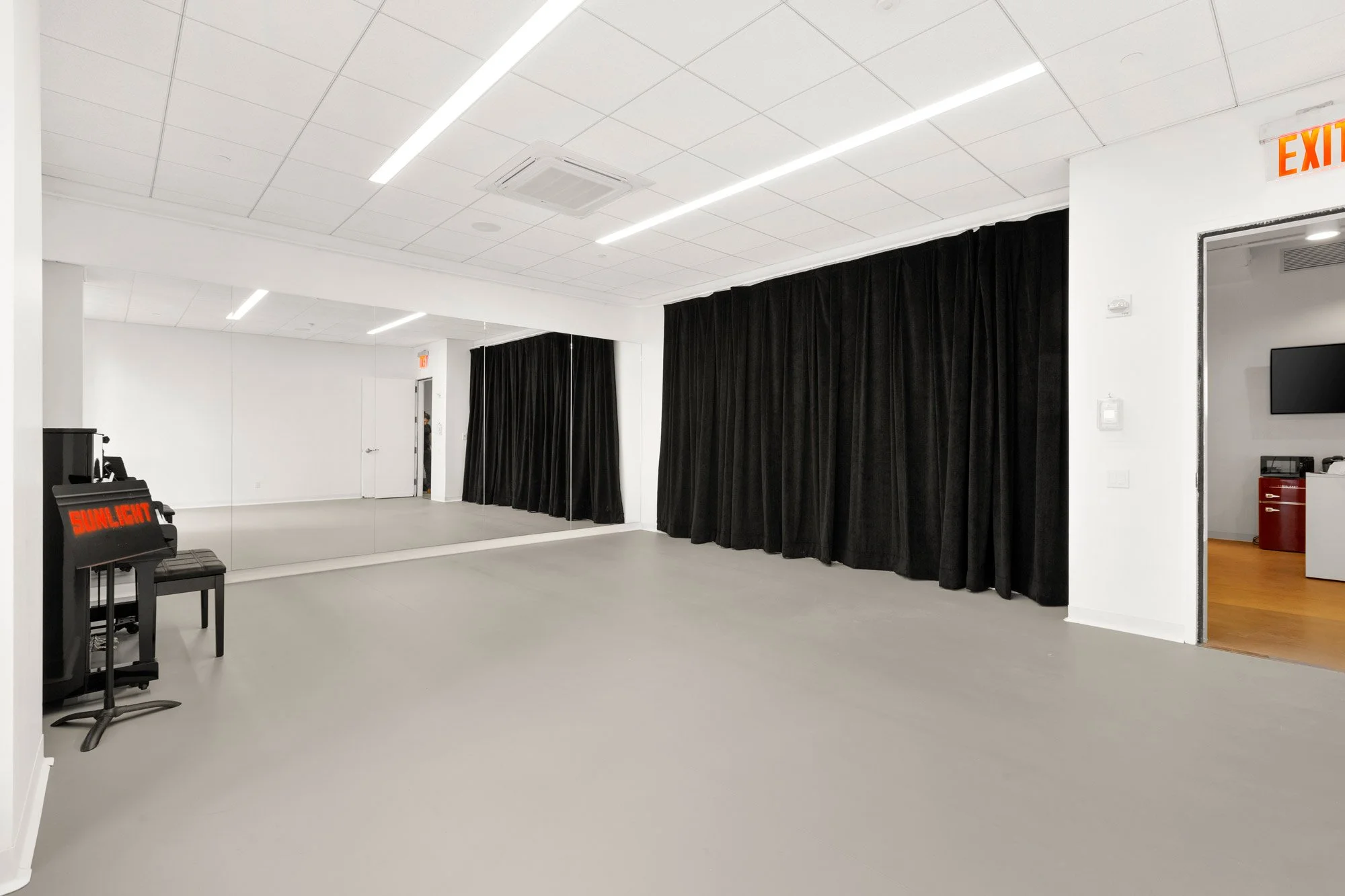 Medium sized studio with windows, marley floors and piano