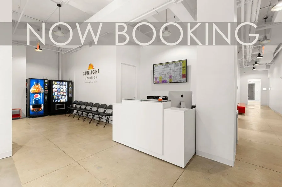 Reception area with concrete floors, front desk, seating for ten, and two snack and drink vending machines.