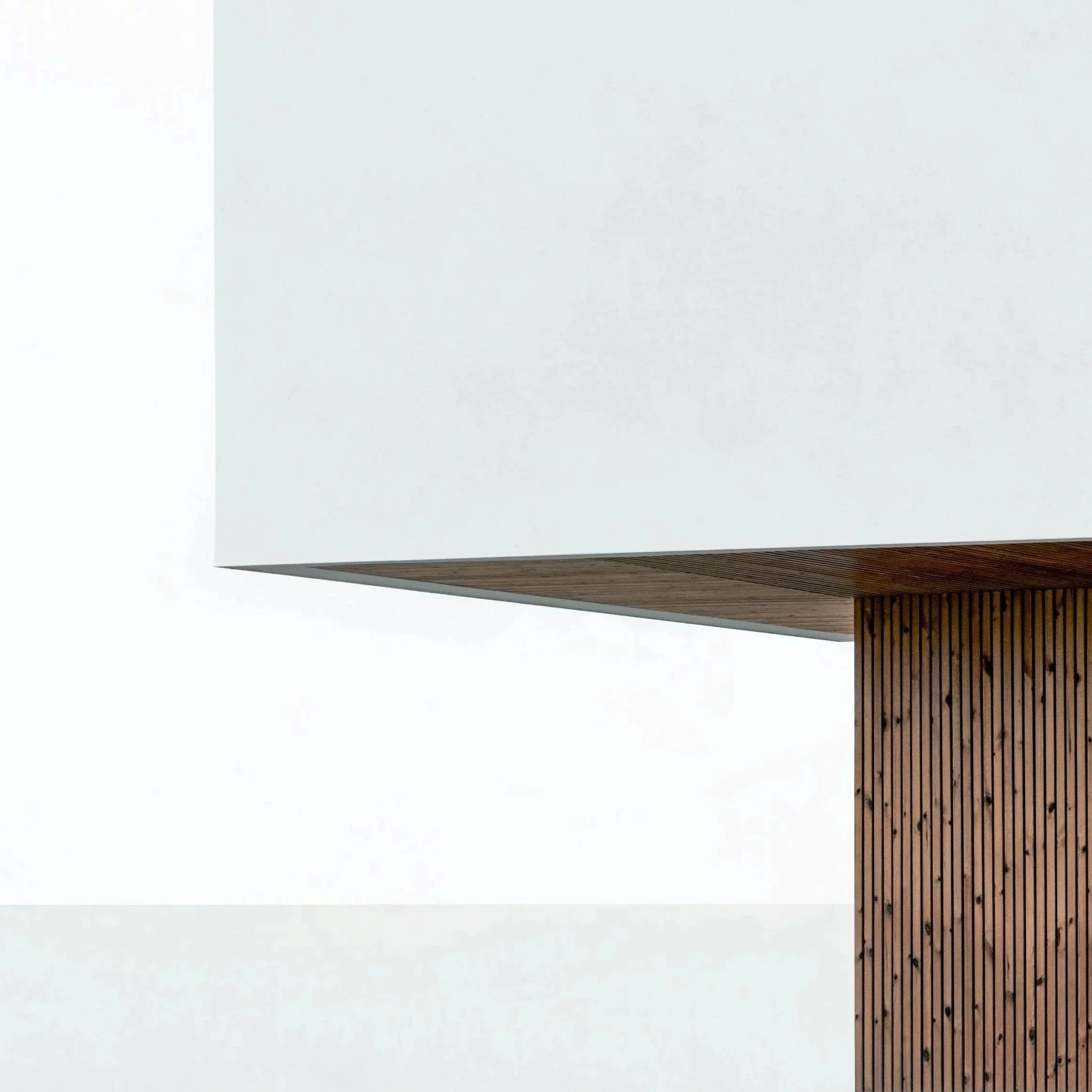 Partie d'un bâtiment moderne avec un mur blanc en haut et un élément en bois vertical en dessous.